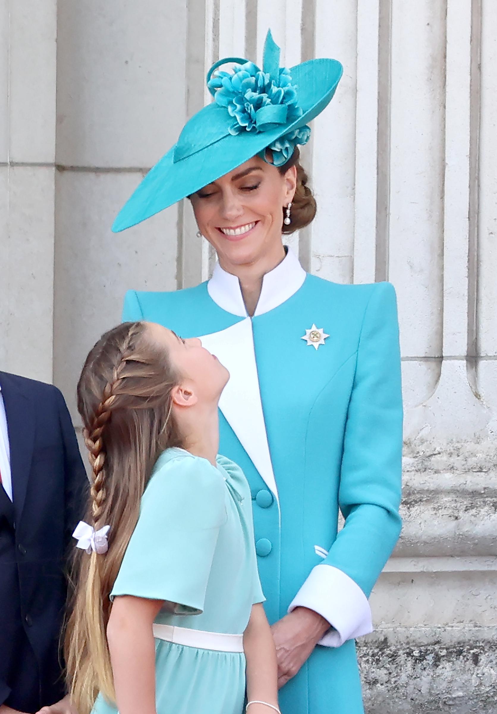 La princesse Catherine échange un tendre sourire avec la princesse Charlotte alors qu'elles se tiennent ensemble sur le balcon du palais de Buckingham lors de la cérémonie du Trooping the Colour de 2025. Charlotte lève les yeux vers sa mère, capturant un échange sincère au milieu de la cérémonie officielle qui marque l'anniversaire officiel du monarque. Ce moment allie la tradition royale à un aperçu intime des liens familiaux.