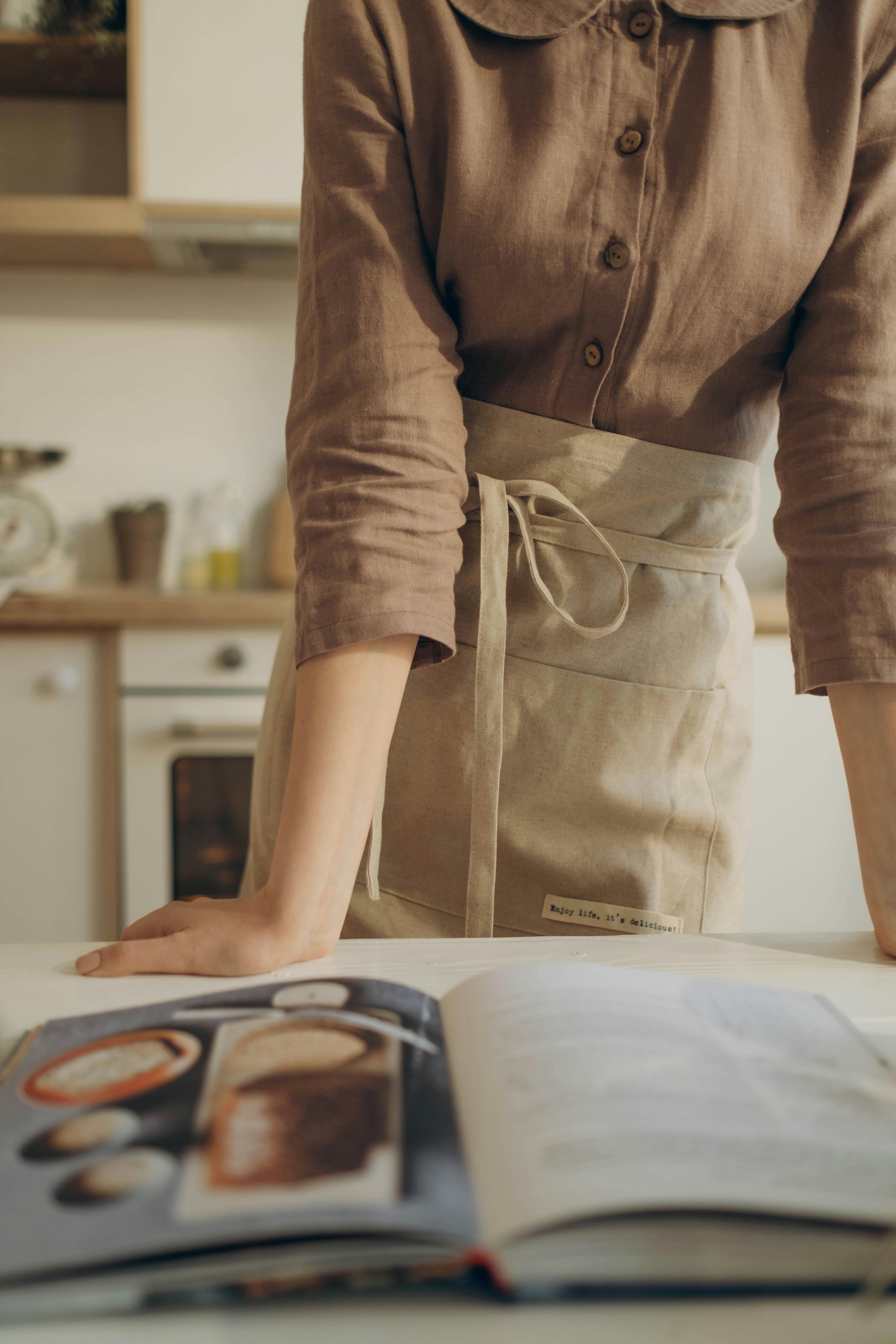 Une femme regarde un livre de cuisine | Source : Pexels