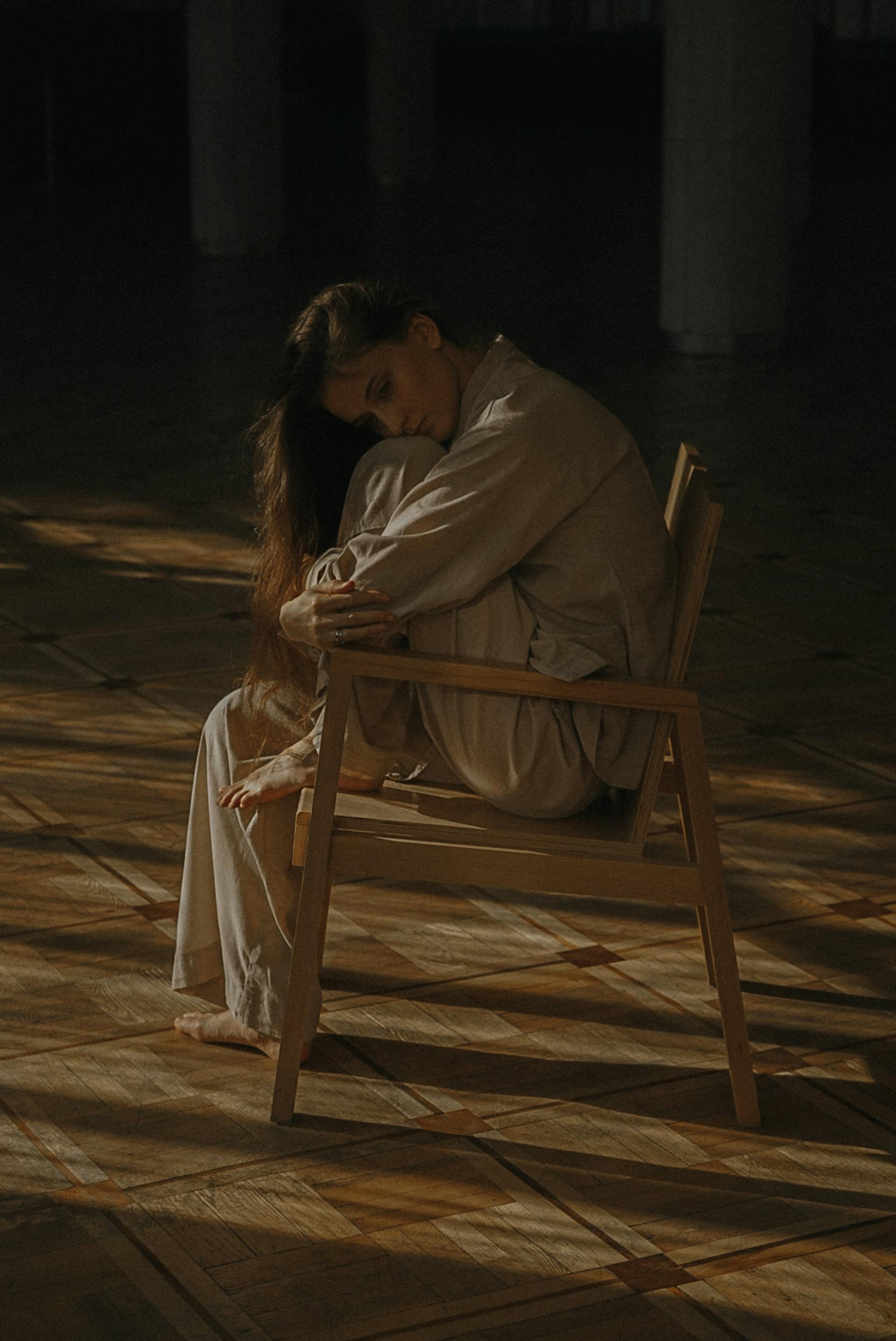 Une femme triste assise sur une chaise | Source : Pexels