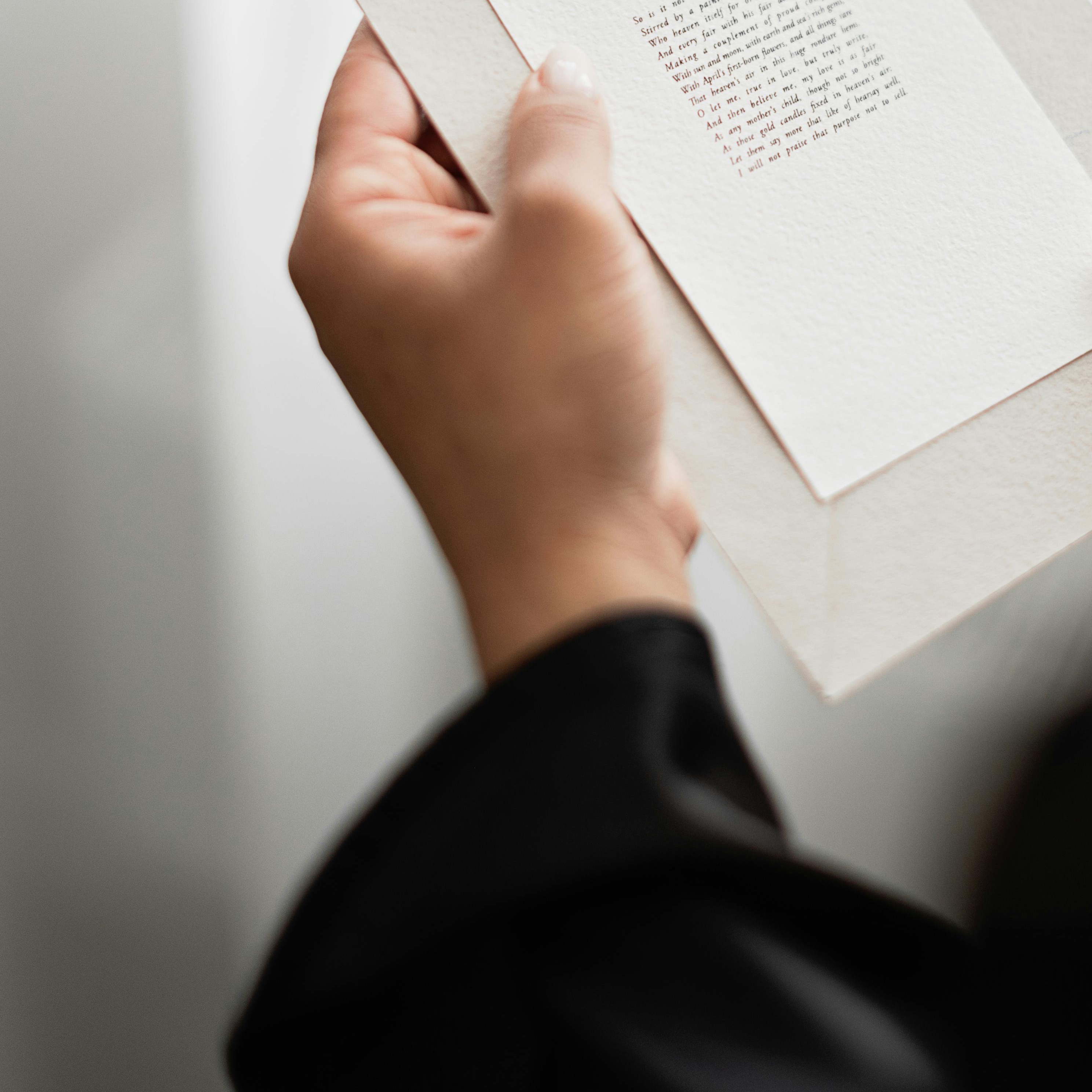 Une main tenant une invitation imprimée | Source : Pexels