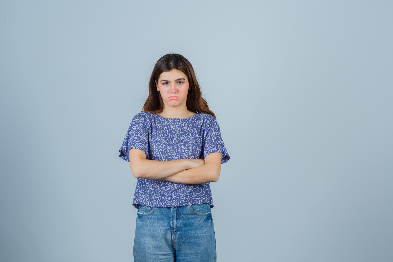 Une jeune femme frustrée avec les bras croisés | Source : Freepik