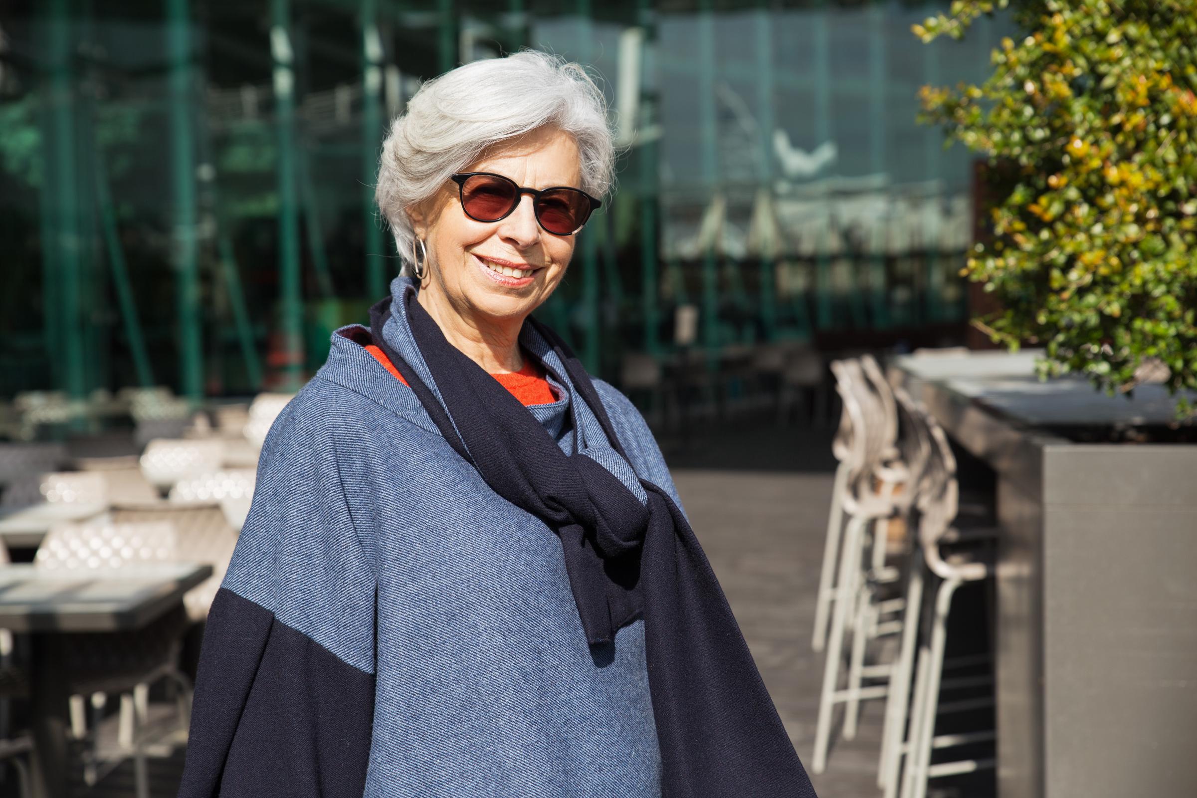Une femme qui sourit en portant des lunettes teintées | Source : Freepik