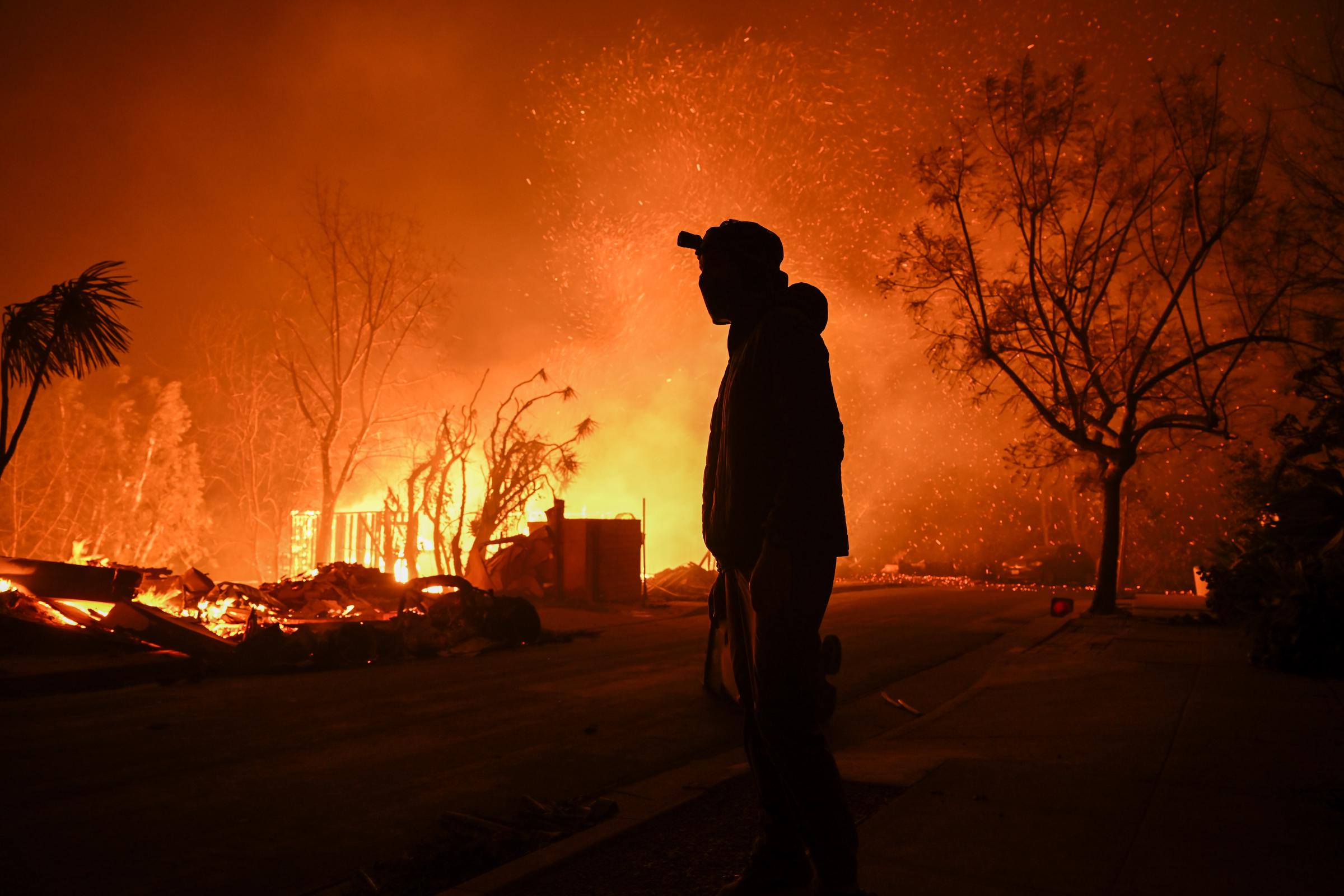 Une personne observe un immeuble résidentiel réduit en cendres à la suite de l'incendie de Palisades, en Californie, le 8 janvier 2025. | Source : Getty Images