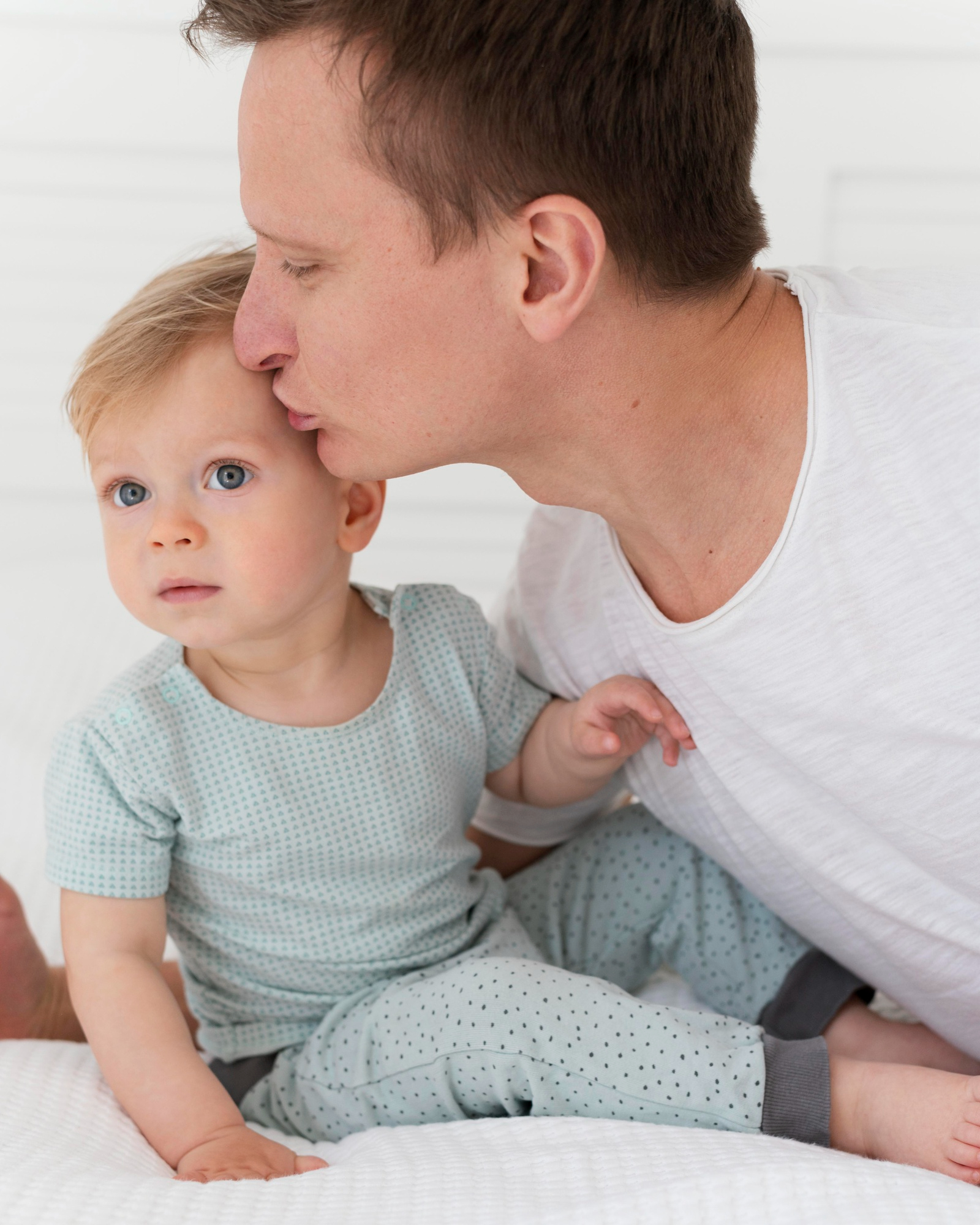 Un jeune homme embrassant la tête d'un bébé | Source : Freepik