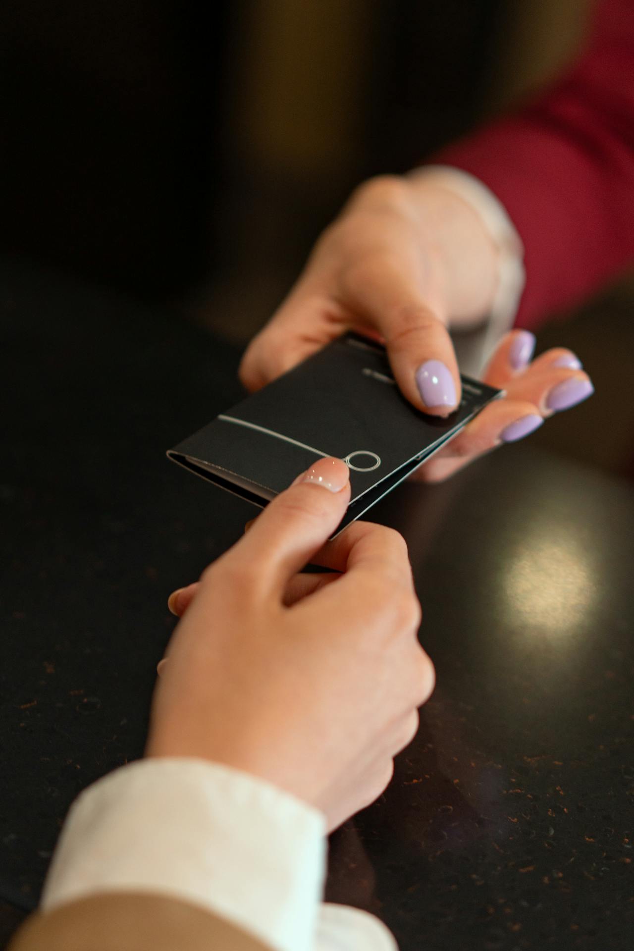 Une femme remettant une carte à une autre femme | Source : Pexels