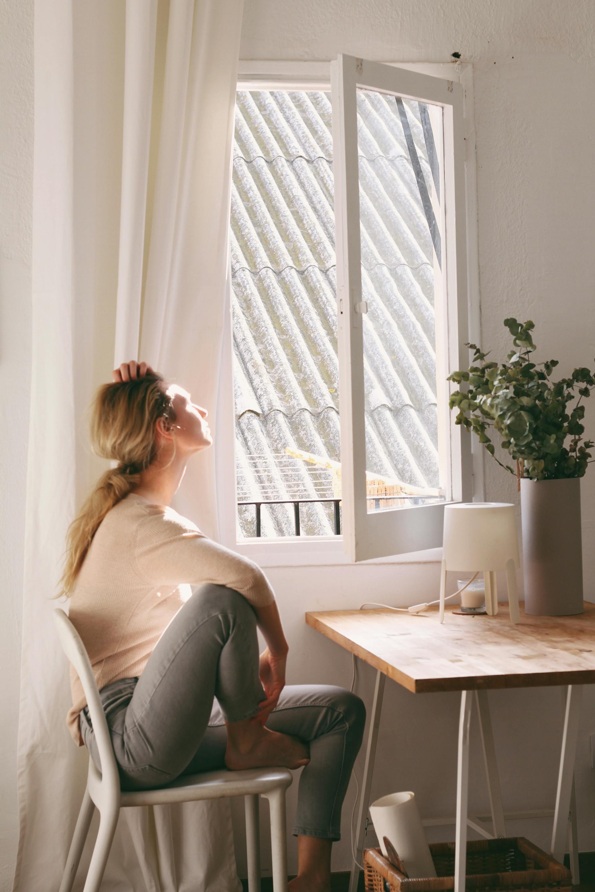 Une femme assise regardant par la fenêtre | Source : Pexels