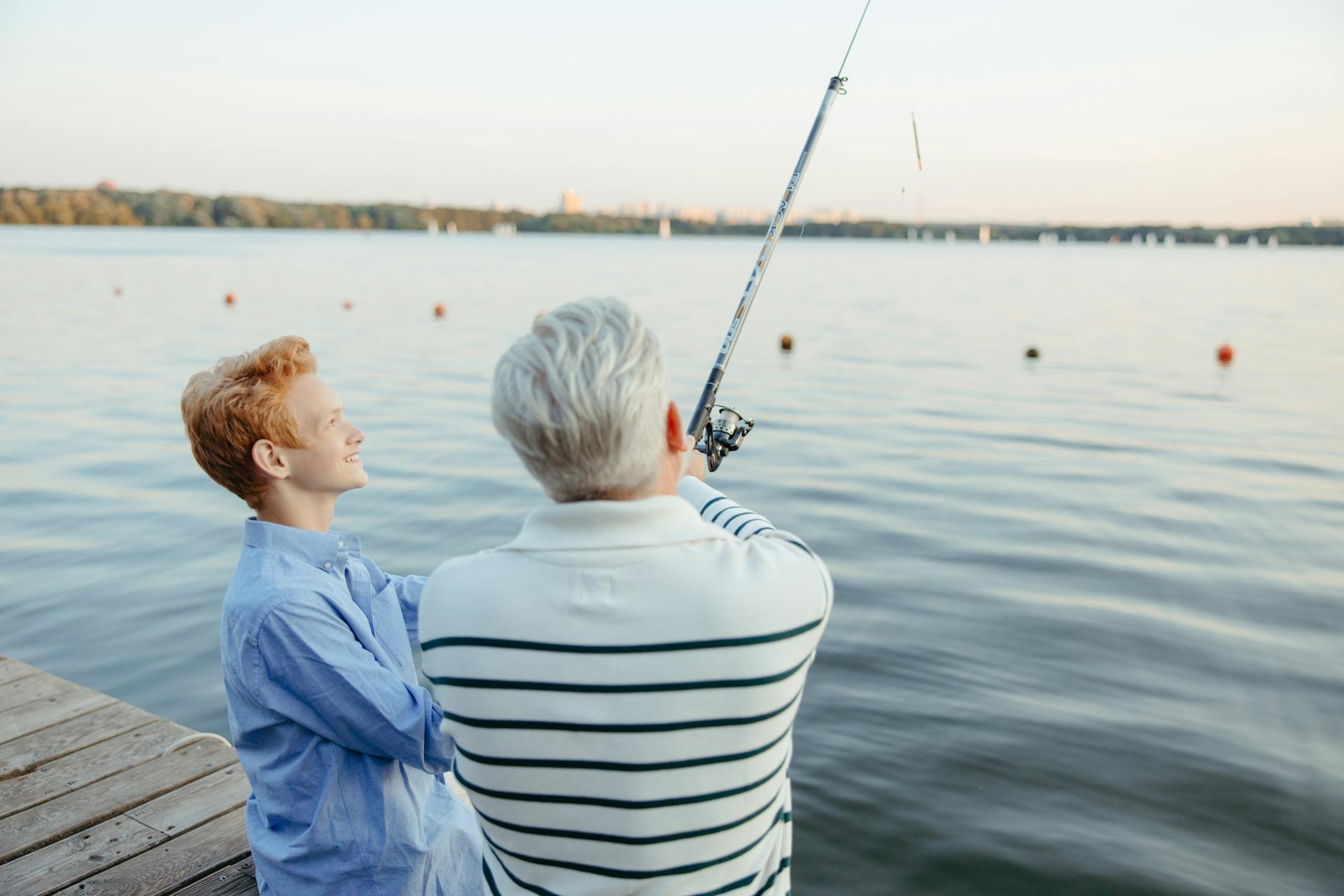 Un homme âgé et un garçon qui pêchent près du quai | Source : Pexels