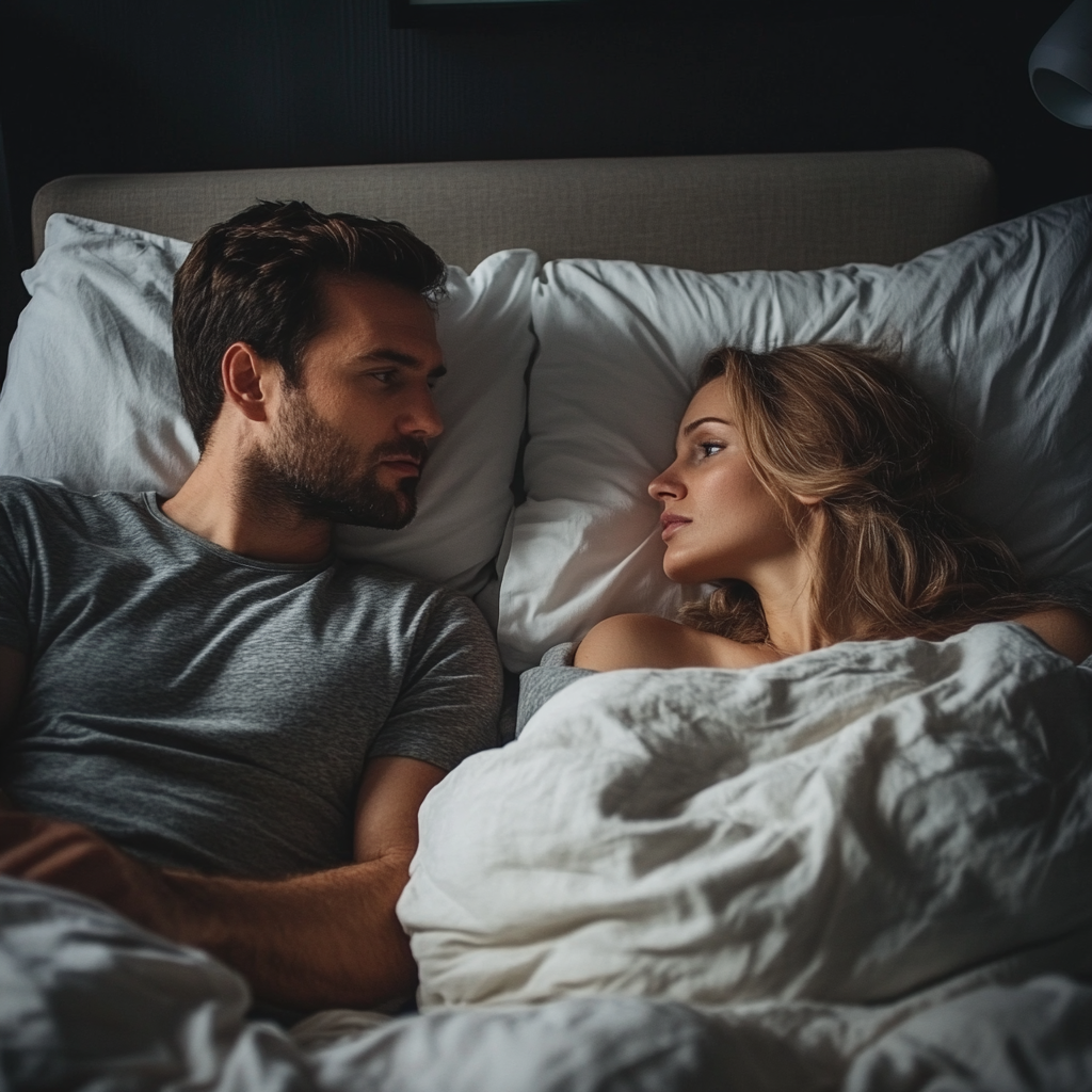 Un homme et une femme qui se regardent au lit | Source : Midjourney