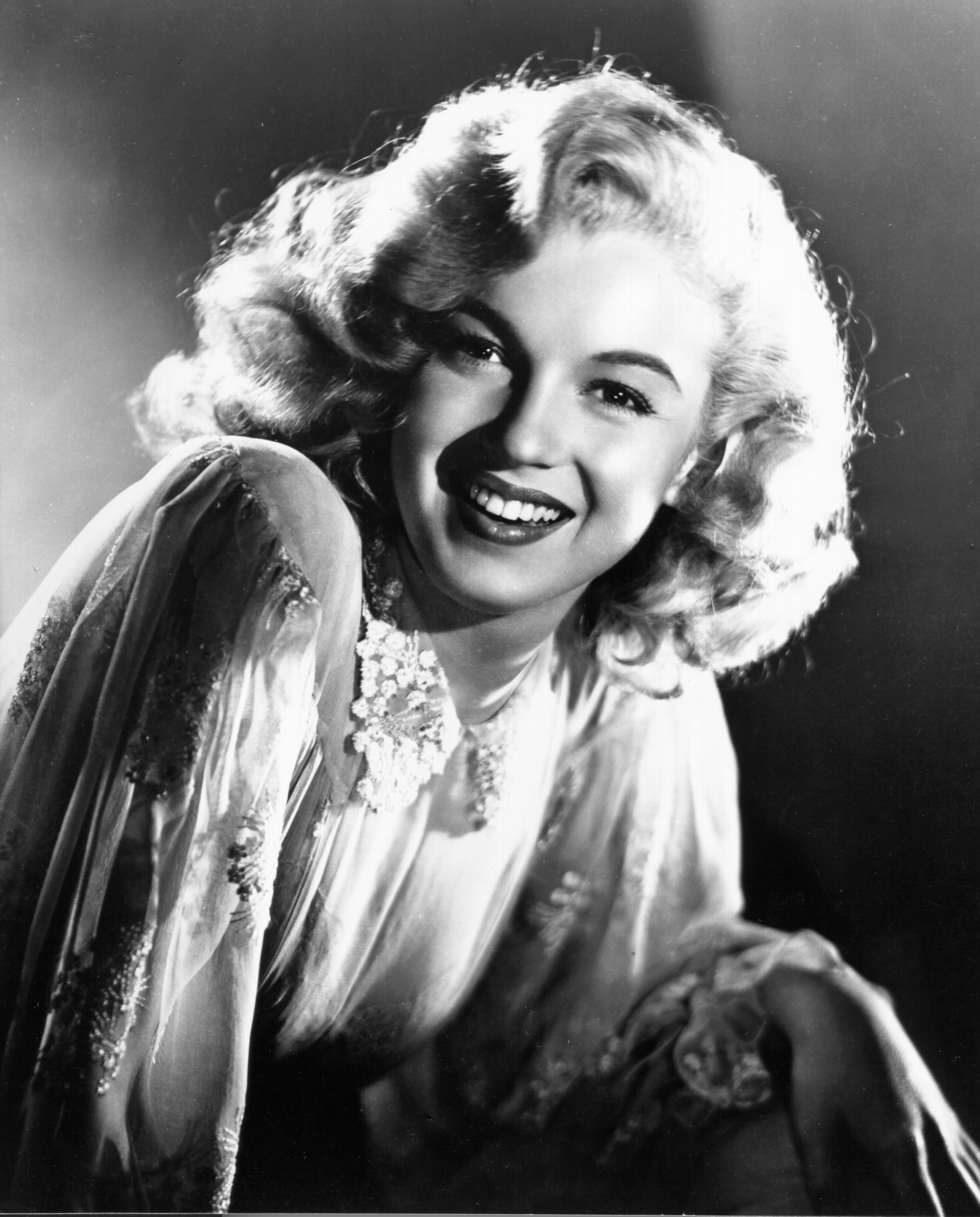 Marilyn Monroe pose pour un portrait en studio, légèrement penchée en avant sous un éclairage contrôlé | Source : Getty Images
