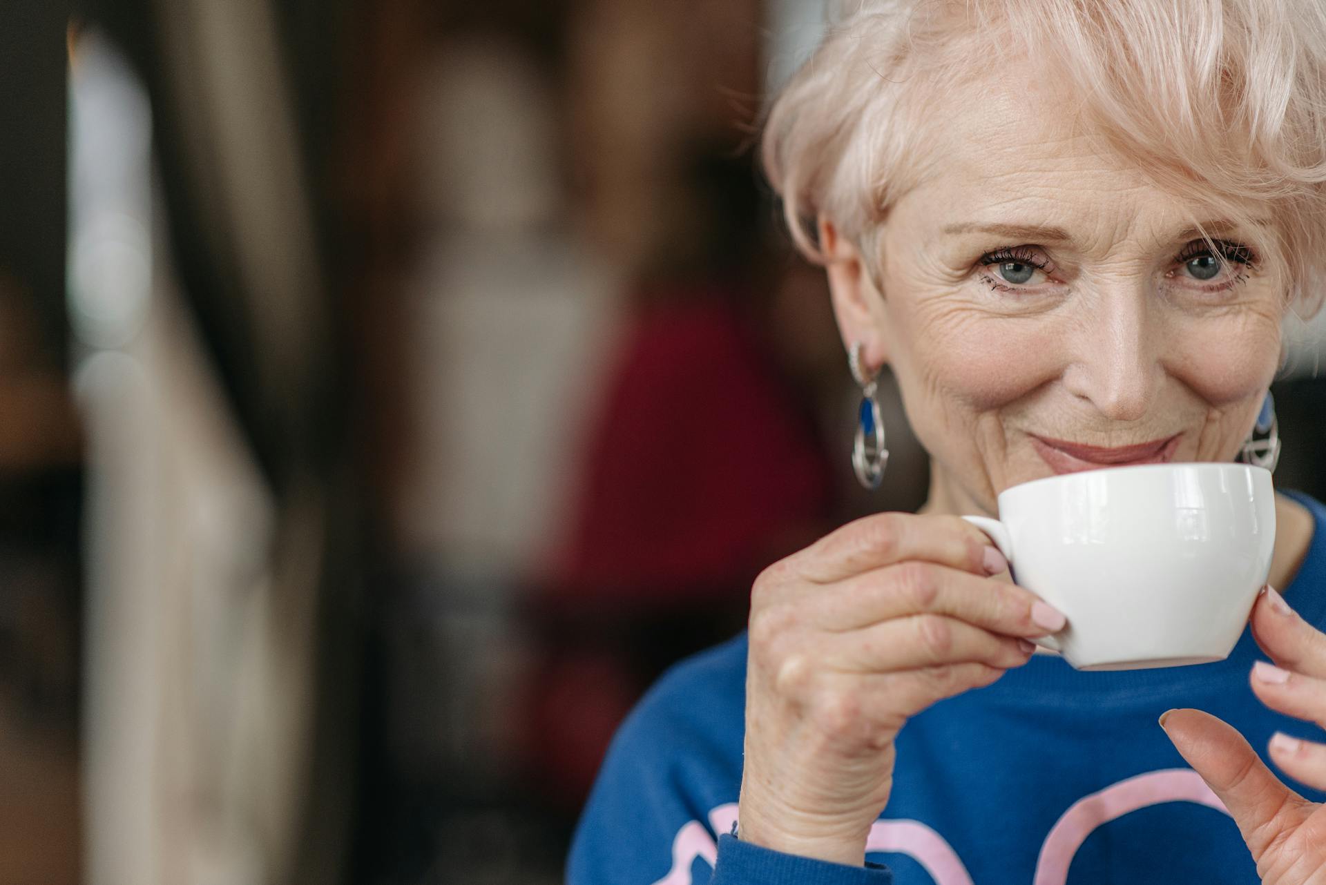Une femme âgée qui sourit en tenant une tasse de café | Source : Pexels