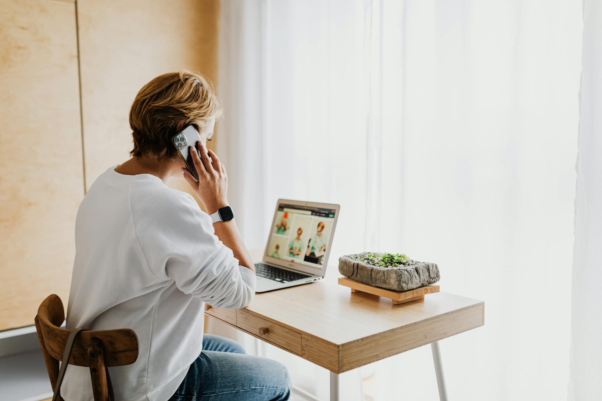 Une femme qui parle sur son téléphone tout en utilisant un ordinateur portable | Source : Pexels