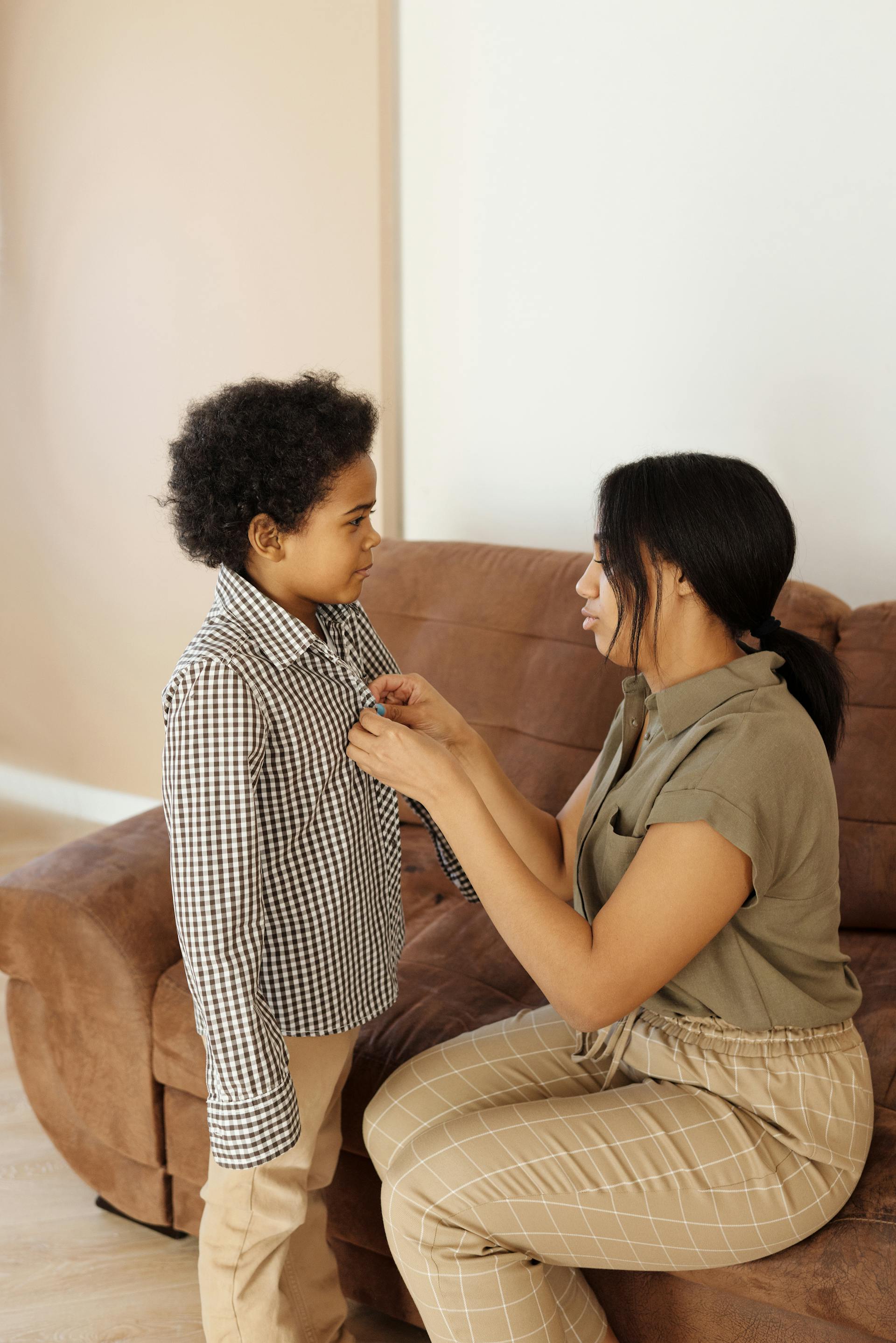 Une mère aidant son fils à s'habiller | Source : Pexels