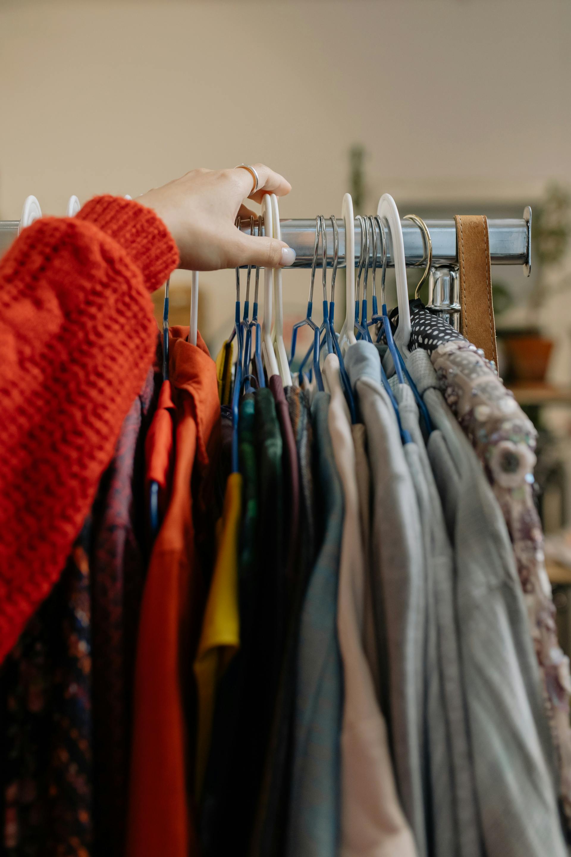 Gros plan d'une personne touchant les vêtements suspendus dans un magasin | Source : Pexels