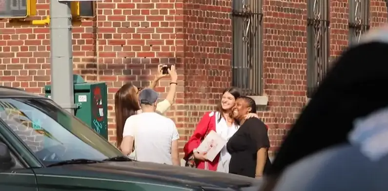 Katie Holmes prend des photos de sa fille le jour de sa remise de diplôme. | Source : YouTube/ Page Six