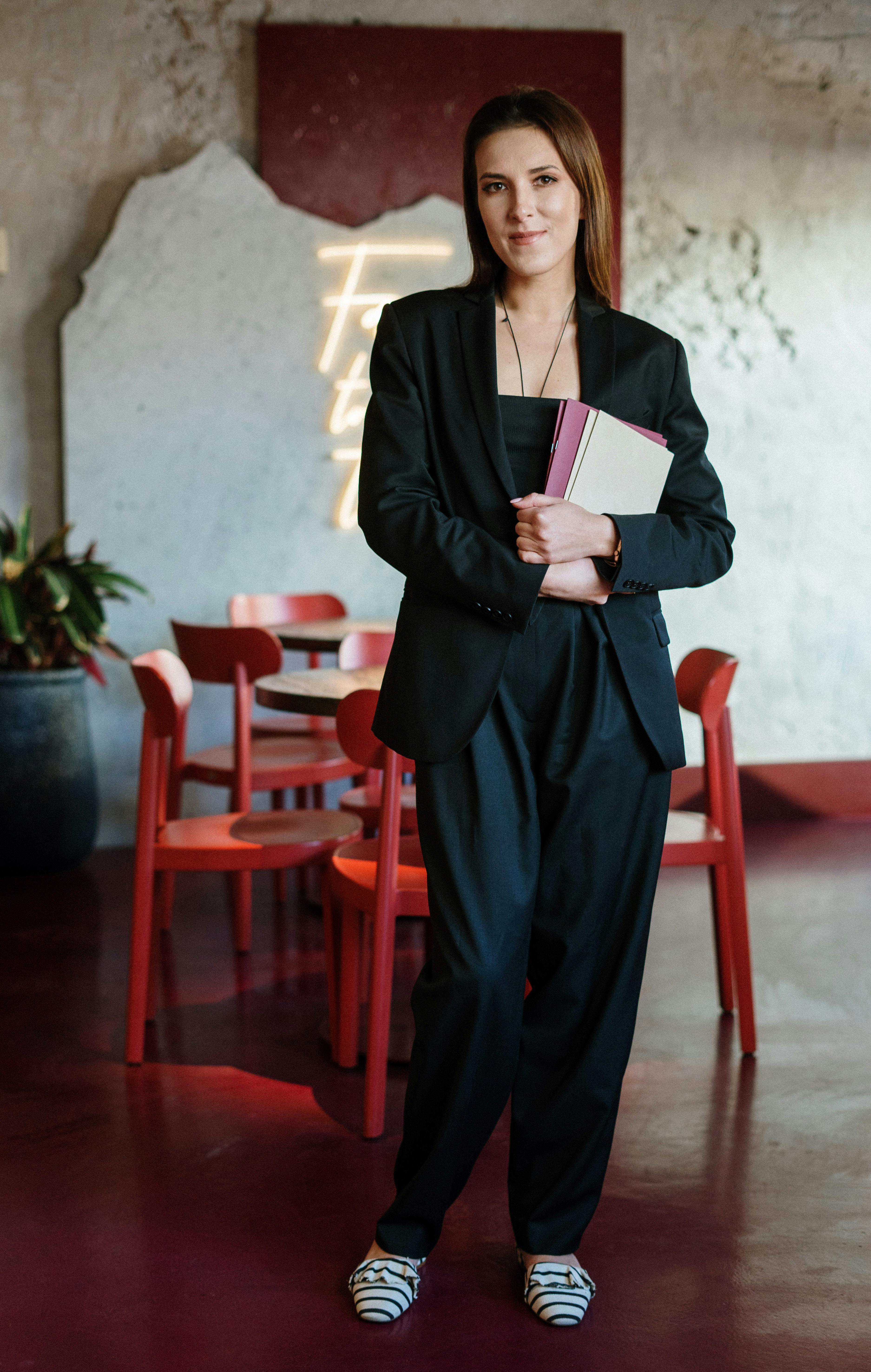 Une femme qui sourit en tenant un cahier | Source : Pexels
