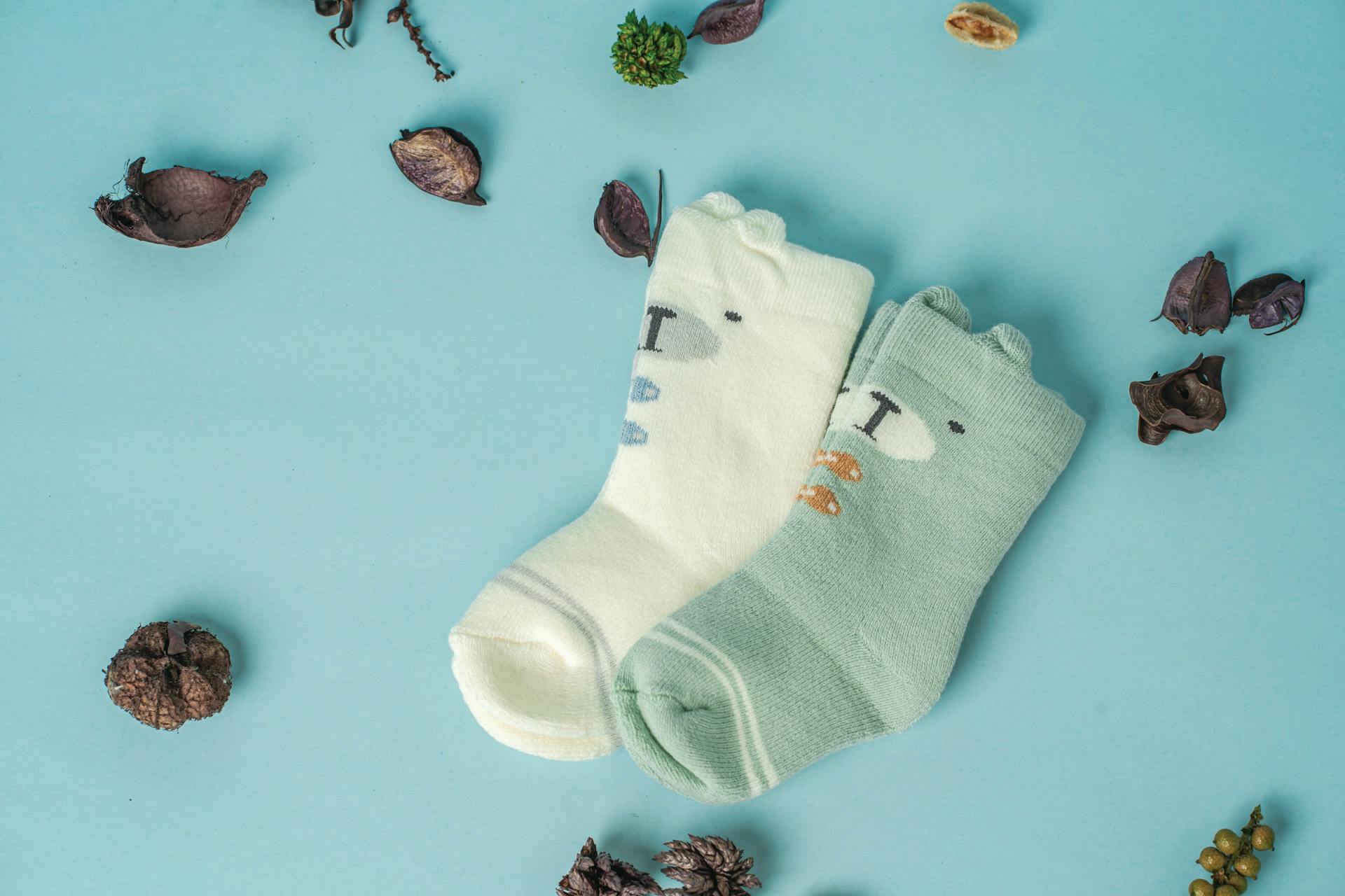 Gros plan sur des chaussettes de bébé posées sur une surface bleue | Source : Pexels