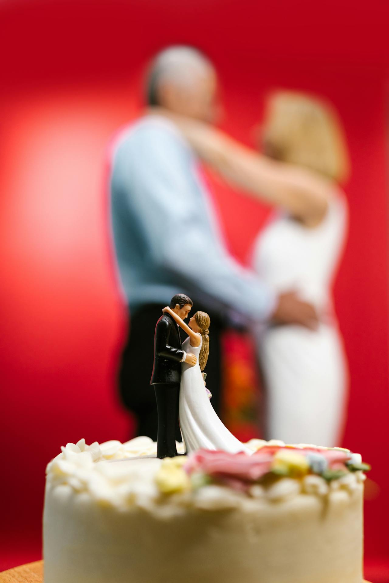 Une mariée et un marié seniors se tenant derrière leur gâteau de mariage | Source : Pexels