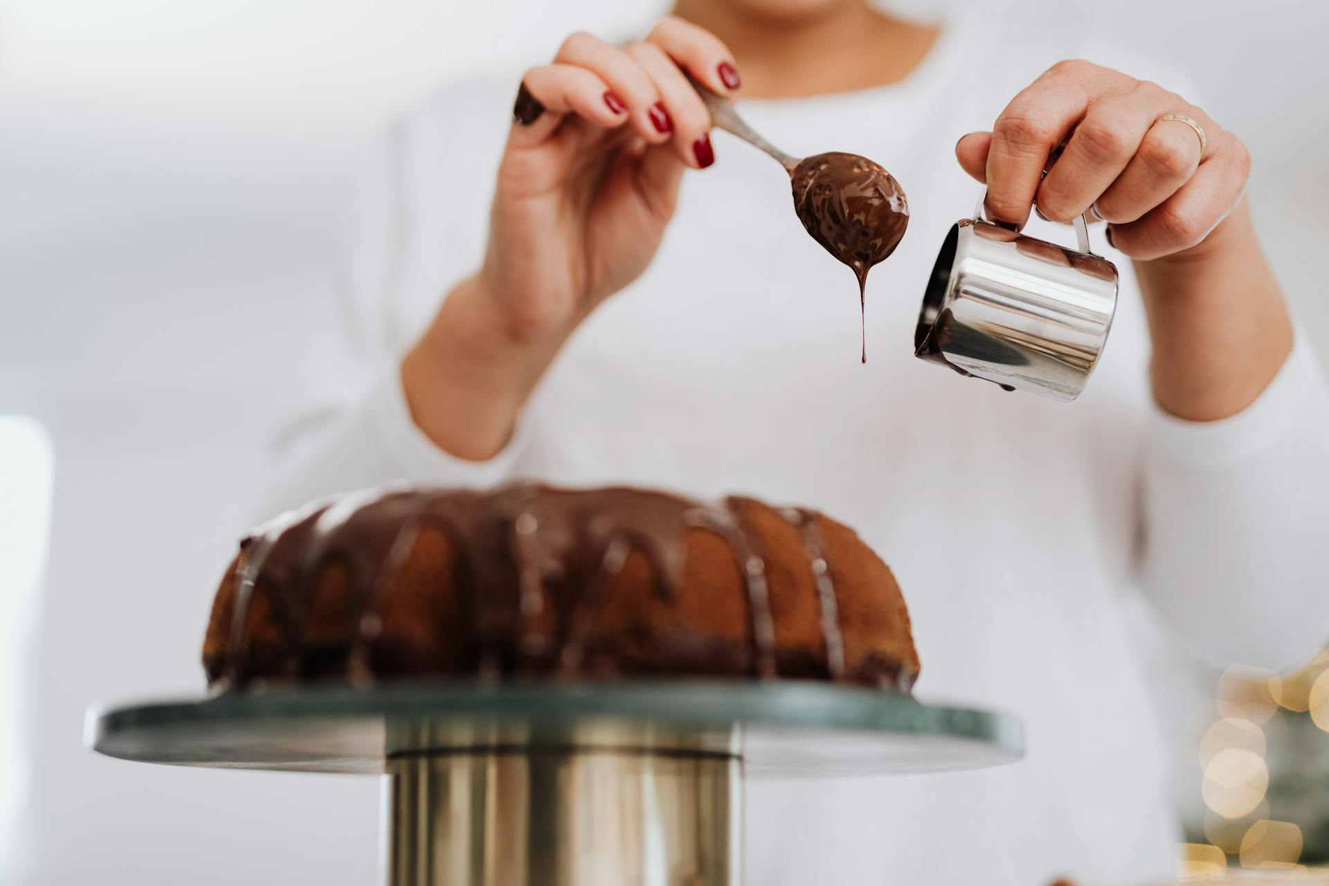 Une femme décore un gâteau avec du chocolat | Source : Pexels