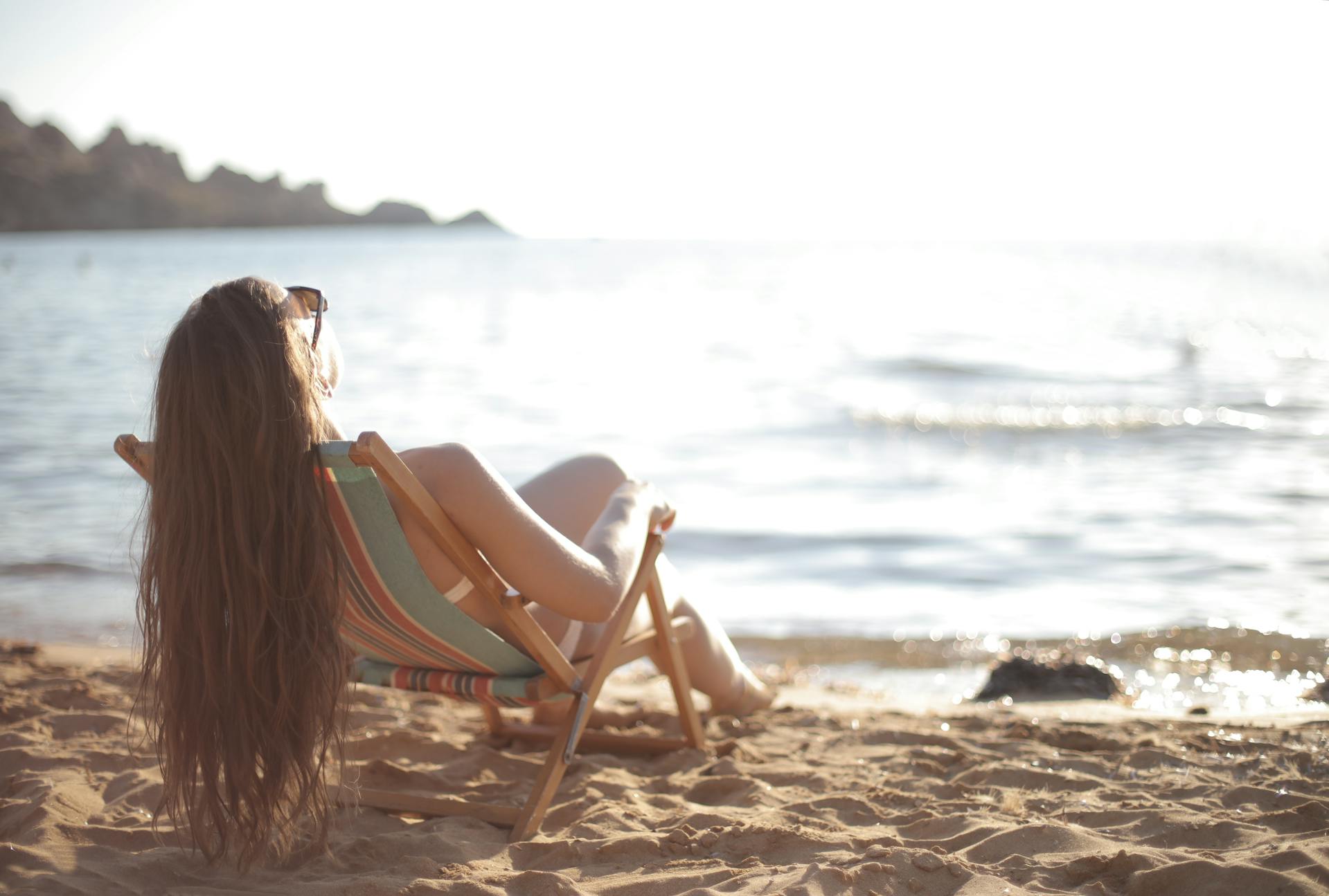 Une femme en maillot de bain allongée sur une chaise de plage | Source : Pexels