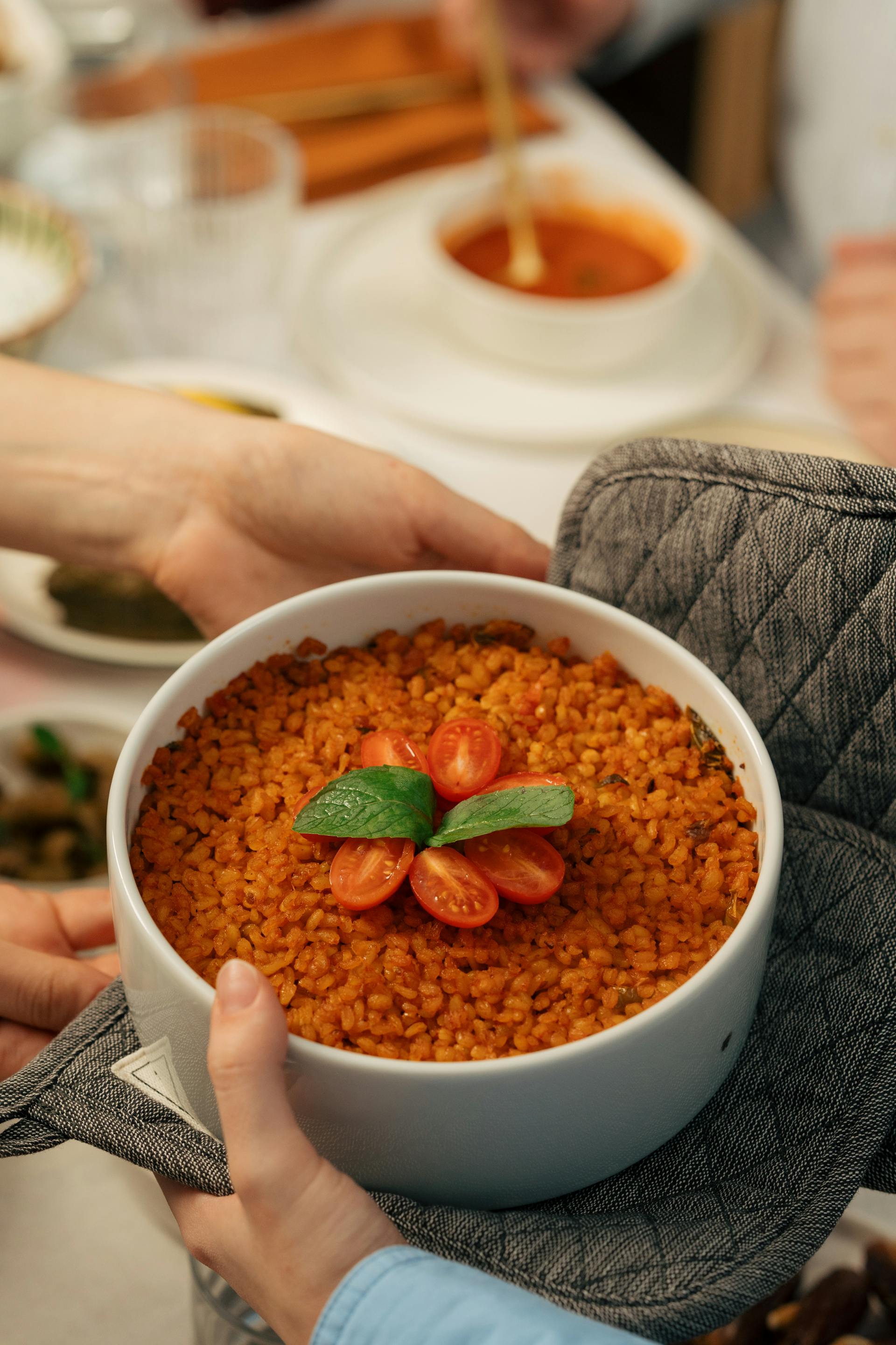 Deux mains tenant un bol de pilaf à la tomate | Source : Pexels