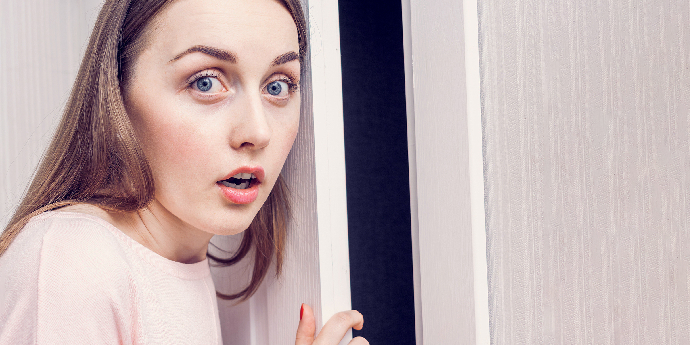 Une femme choquée se tenant devant une porte d'entrée | Source : Shutterstock