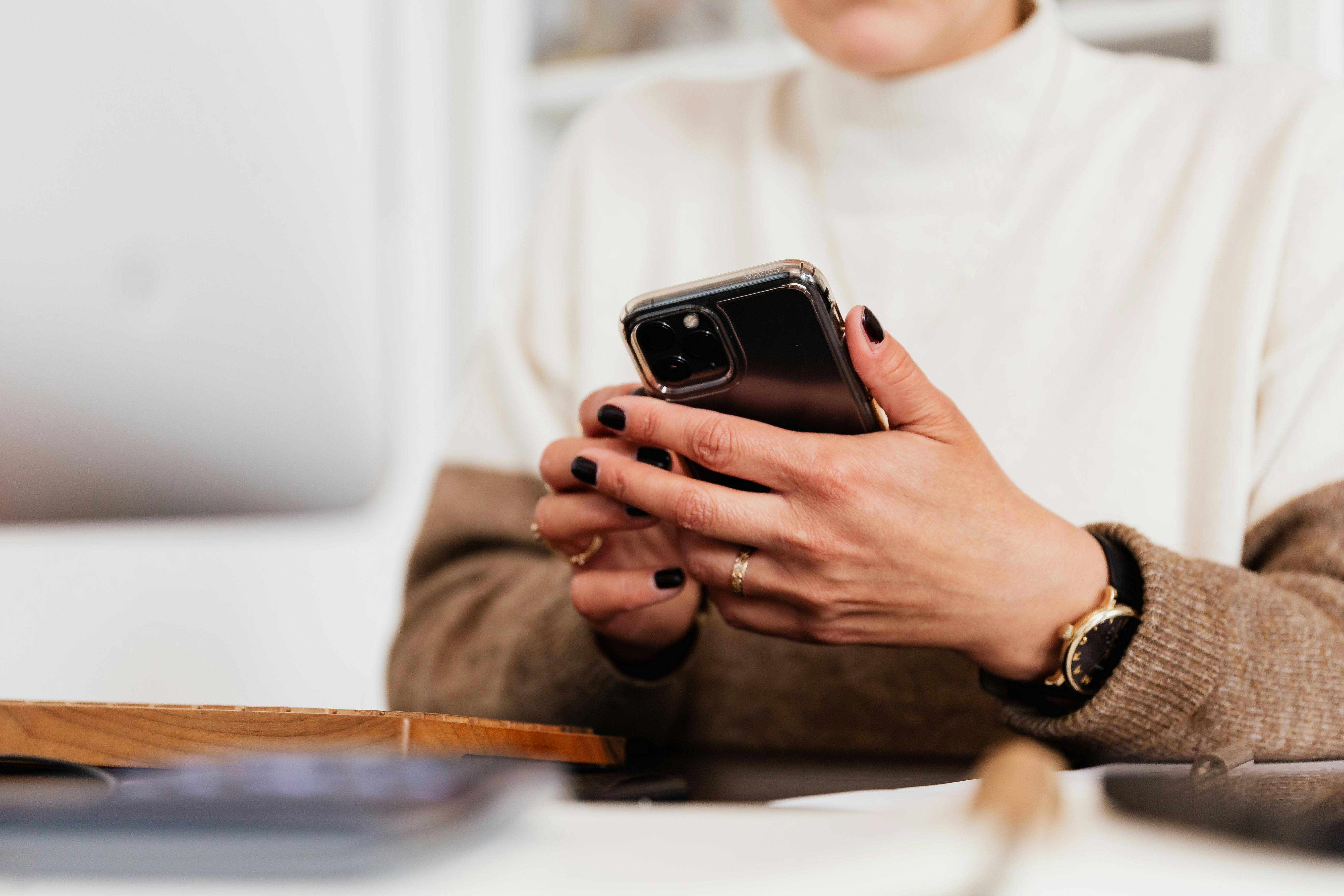 Une femme tenant son smartphone | Source : Pexels