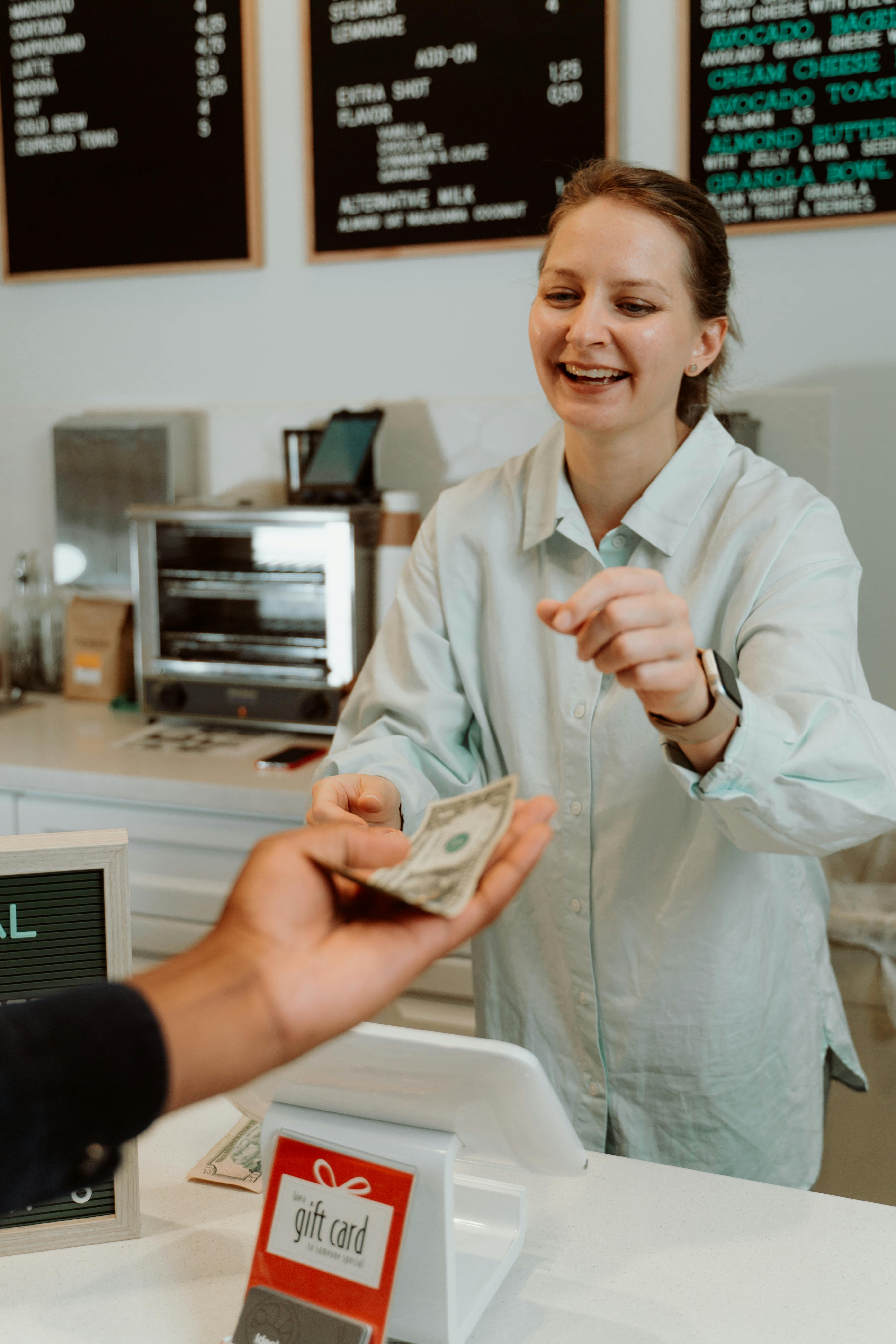 Une femme recevant de l'argent d'un client | Source : Pexels