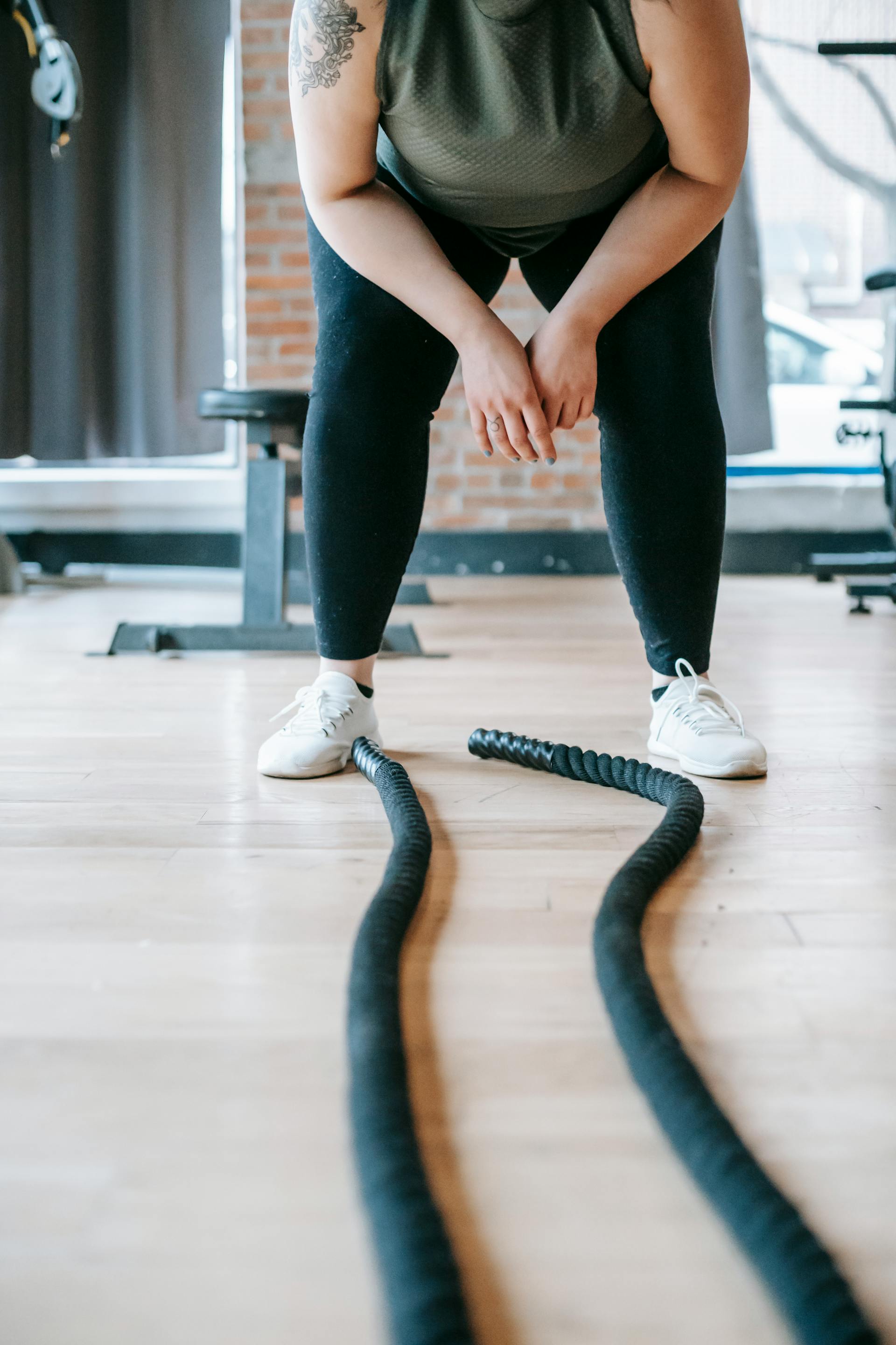 Une femme de grande taille se repose après avoir fait de l'exercice avec des cordes | Source : Pexels