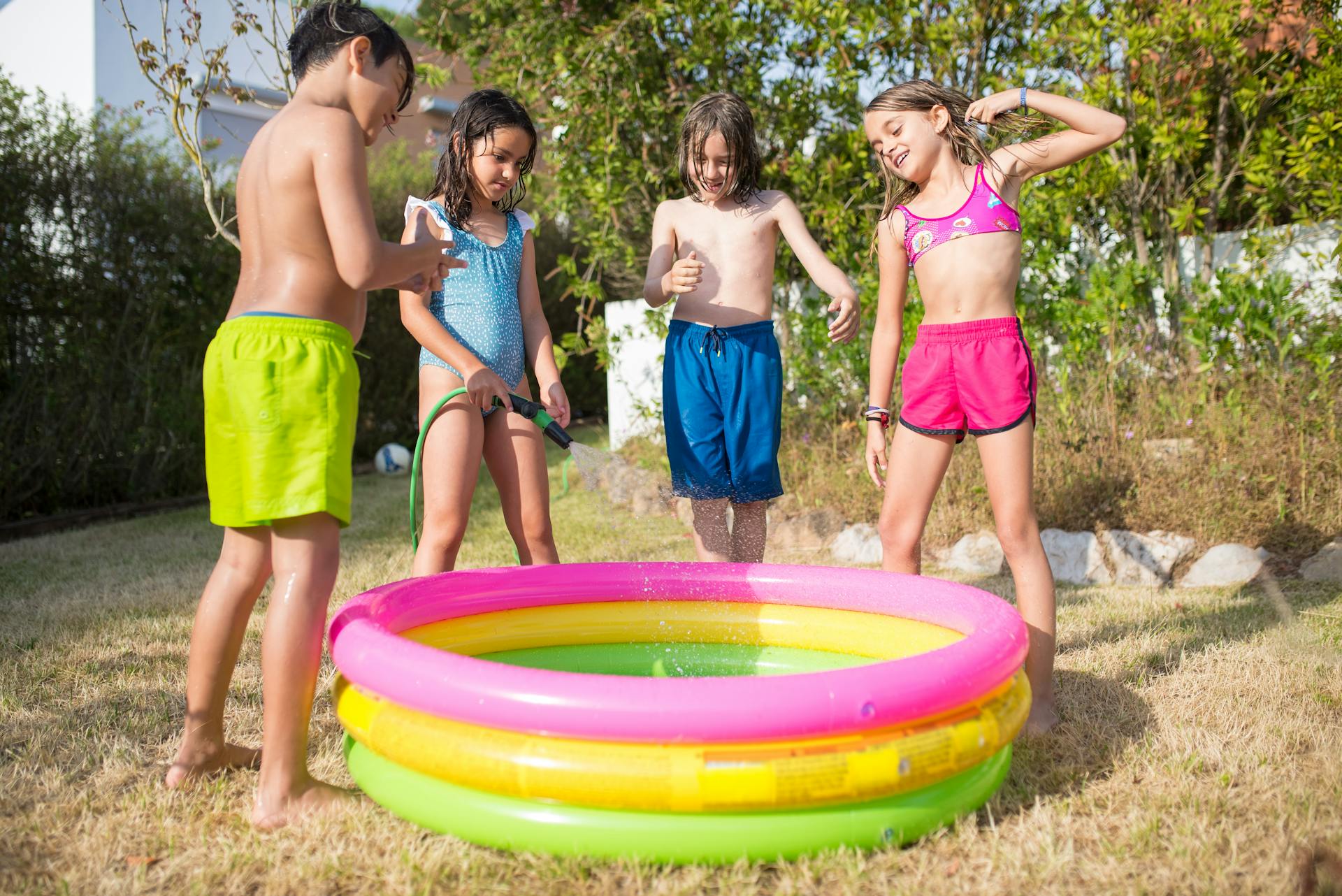 Des enfants se tiennent autour d'une piscine gonflable | Source : Pexels