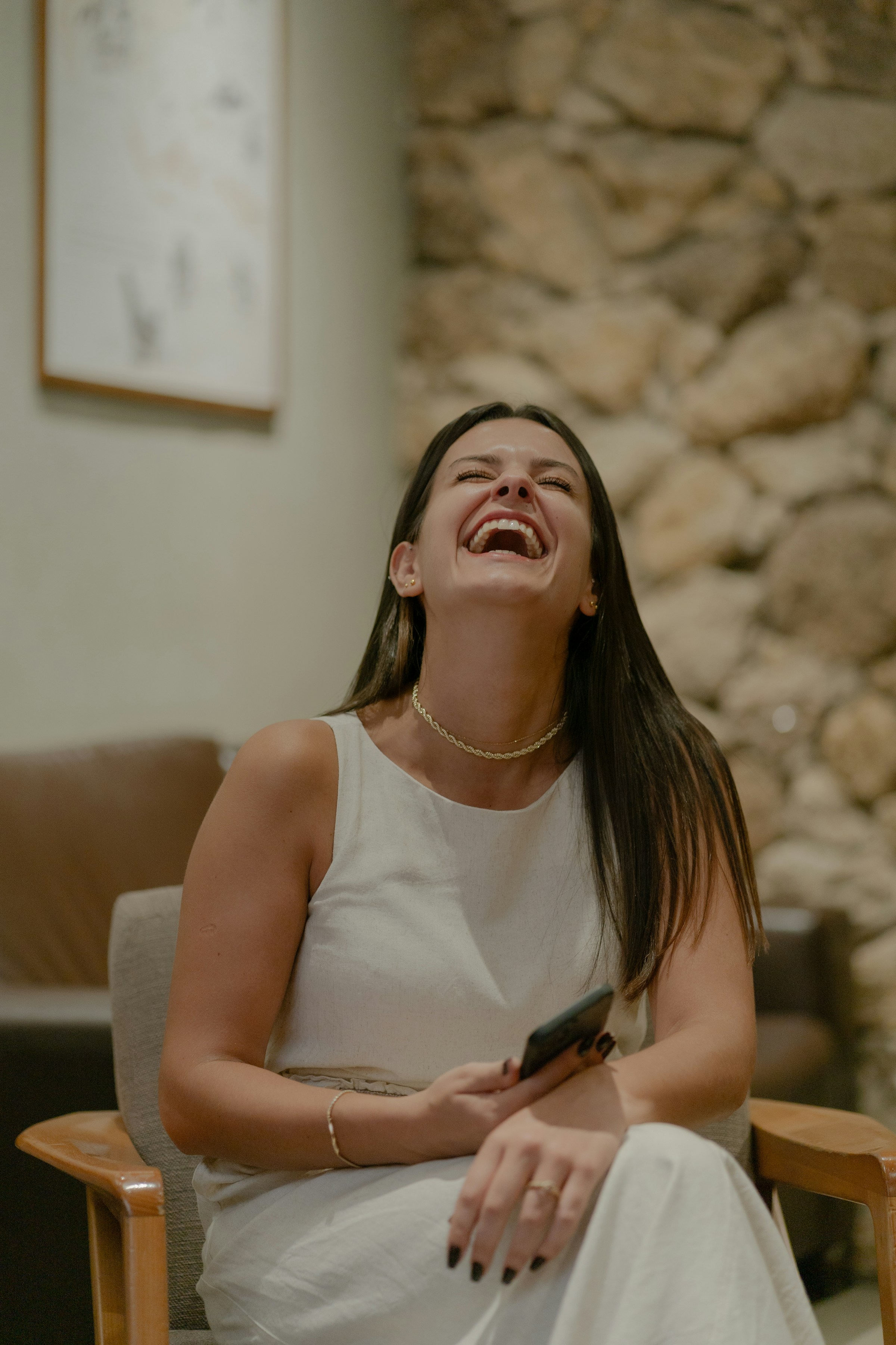 Une femme qui rit en tenant son téléphone | Source : Unsplash