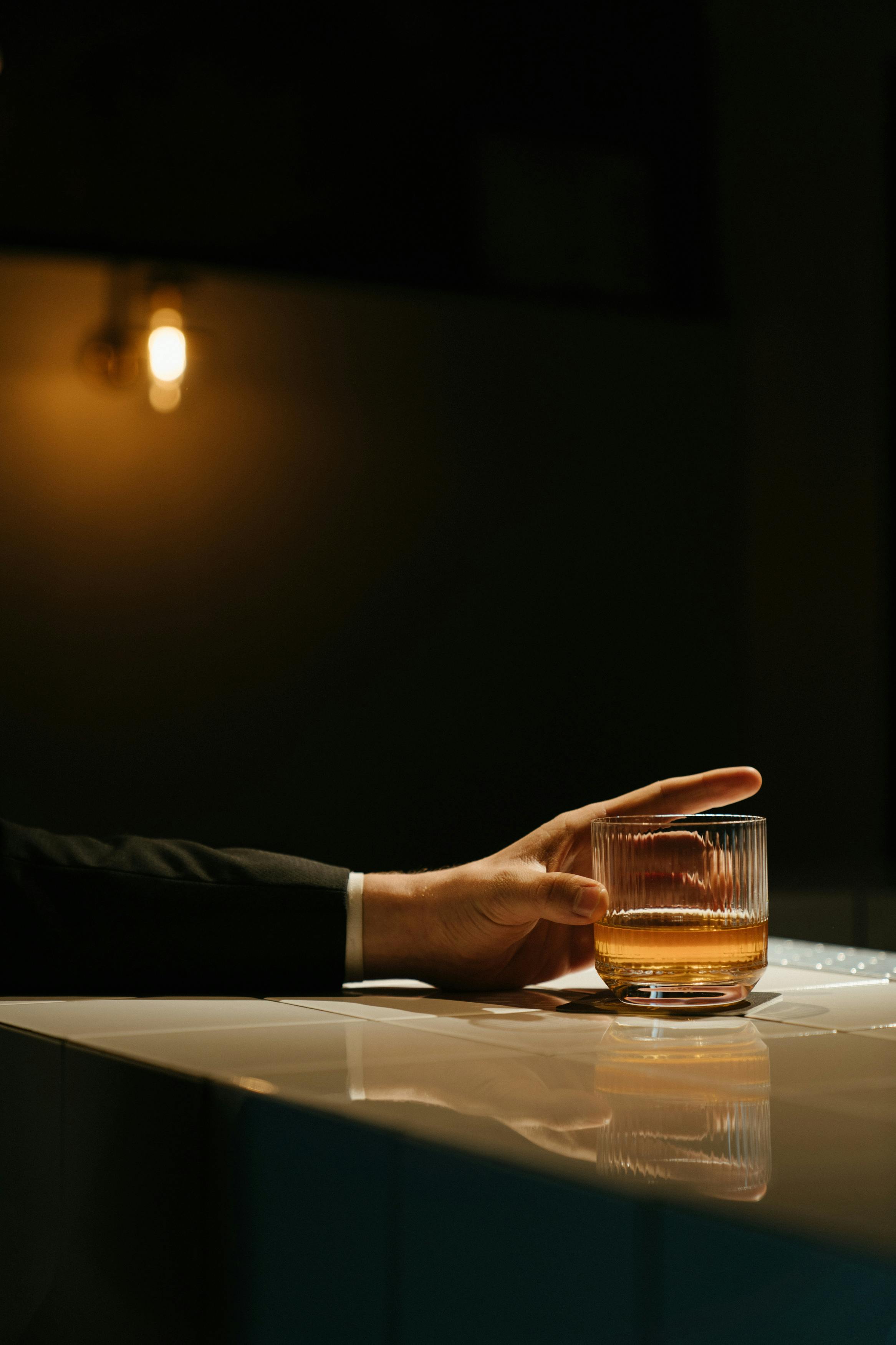 Un homme tenant un verre dans un bar | Source : Pexels