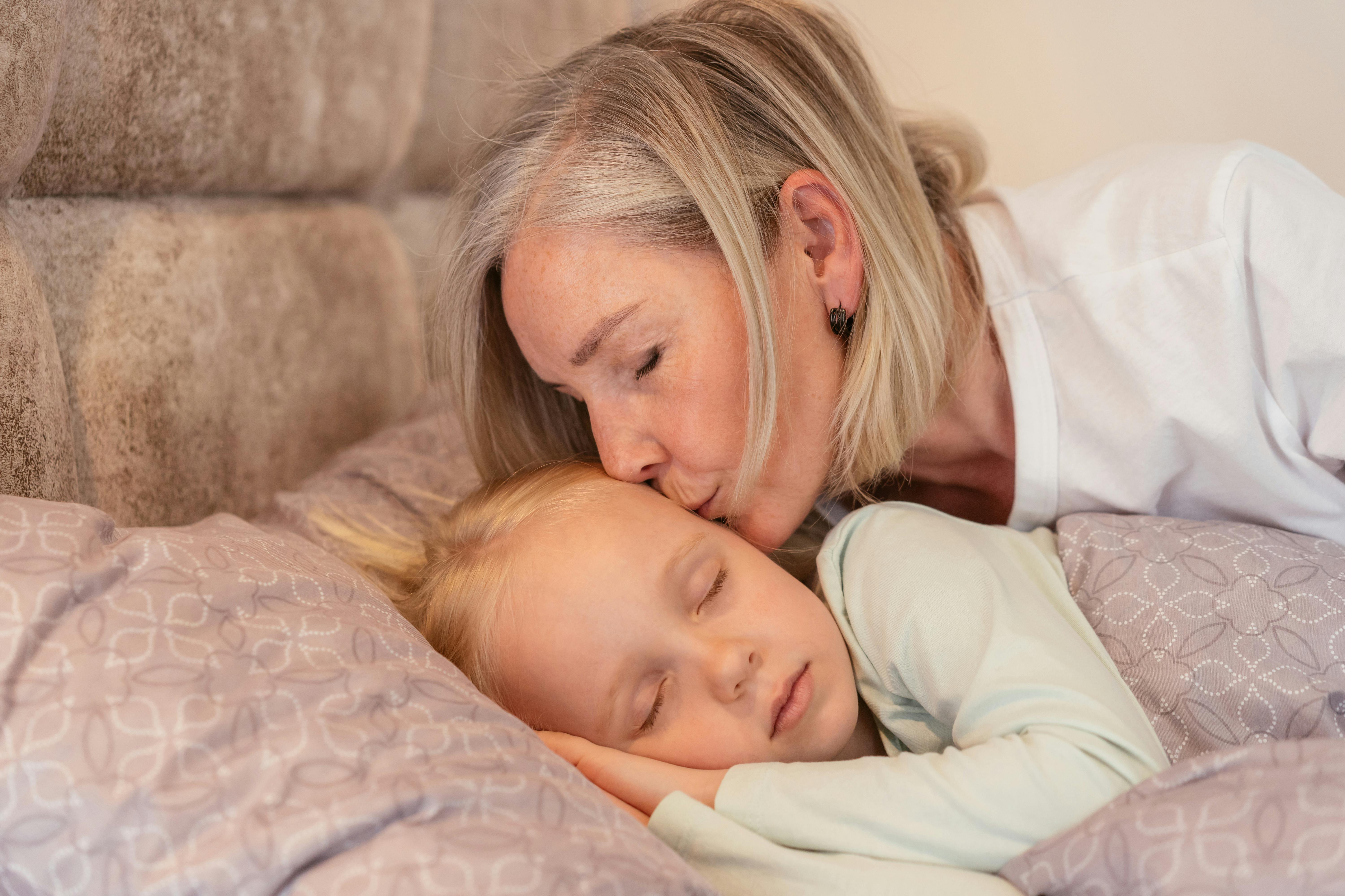 Une grand-mère bordant sa petite-fille dans son lit | Source : Pexels