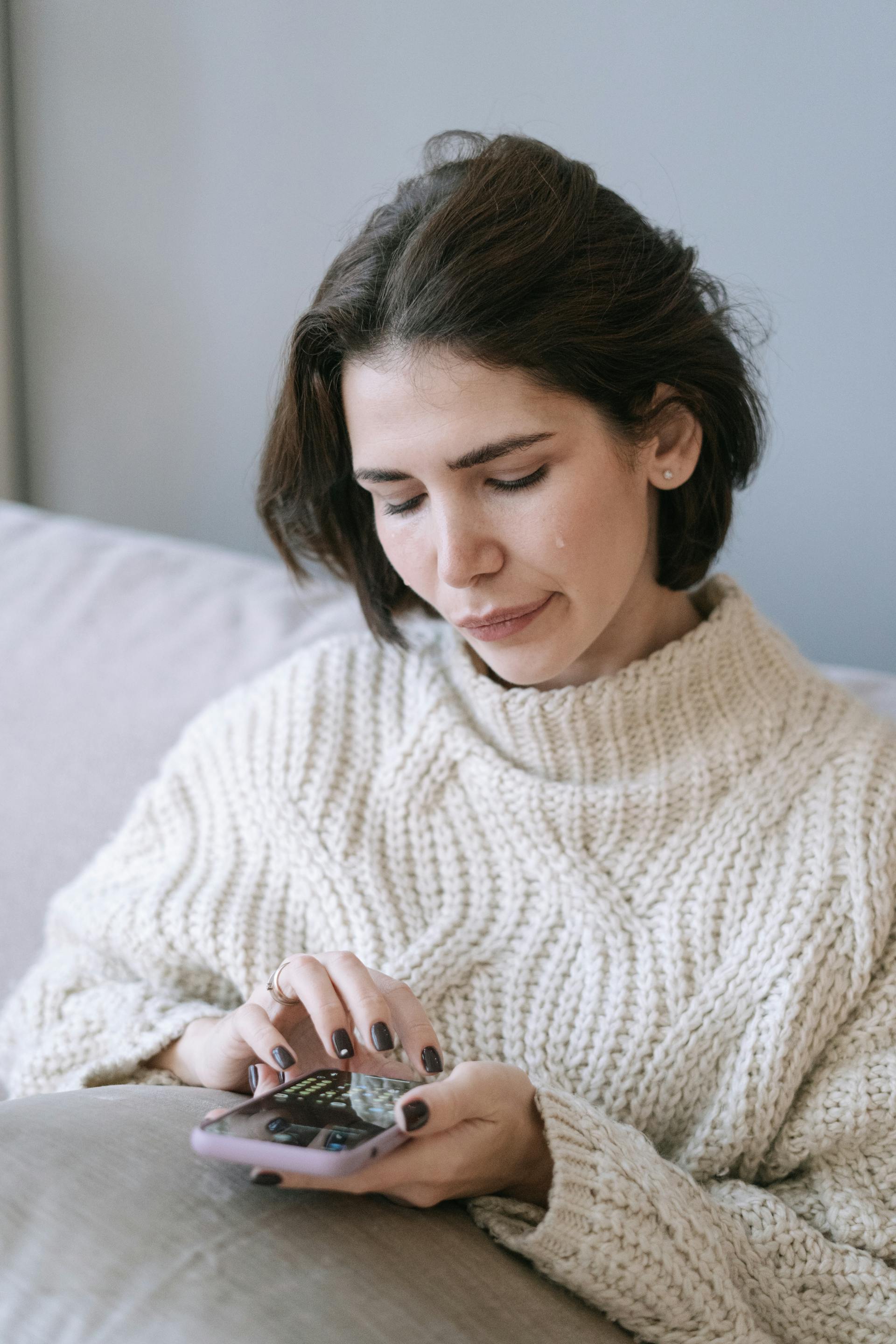Une femme en pleurs tenant un téléphone portable | Source : Pexels
