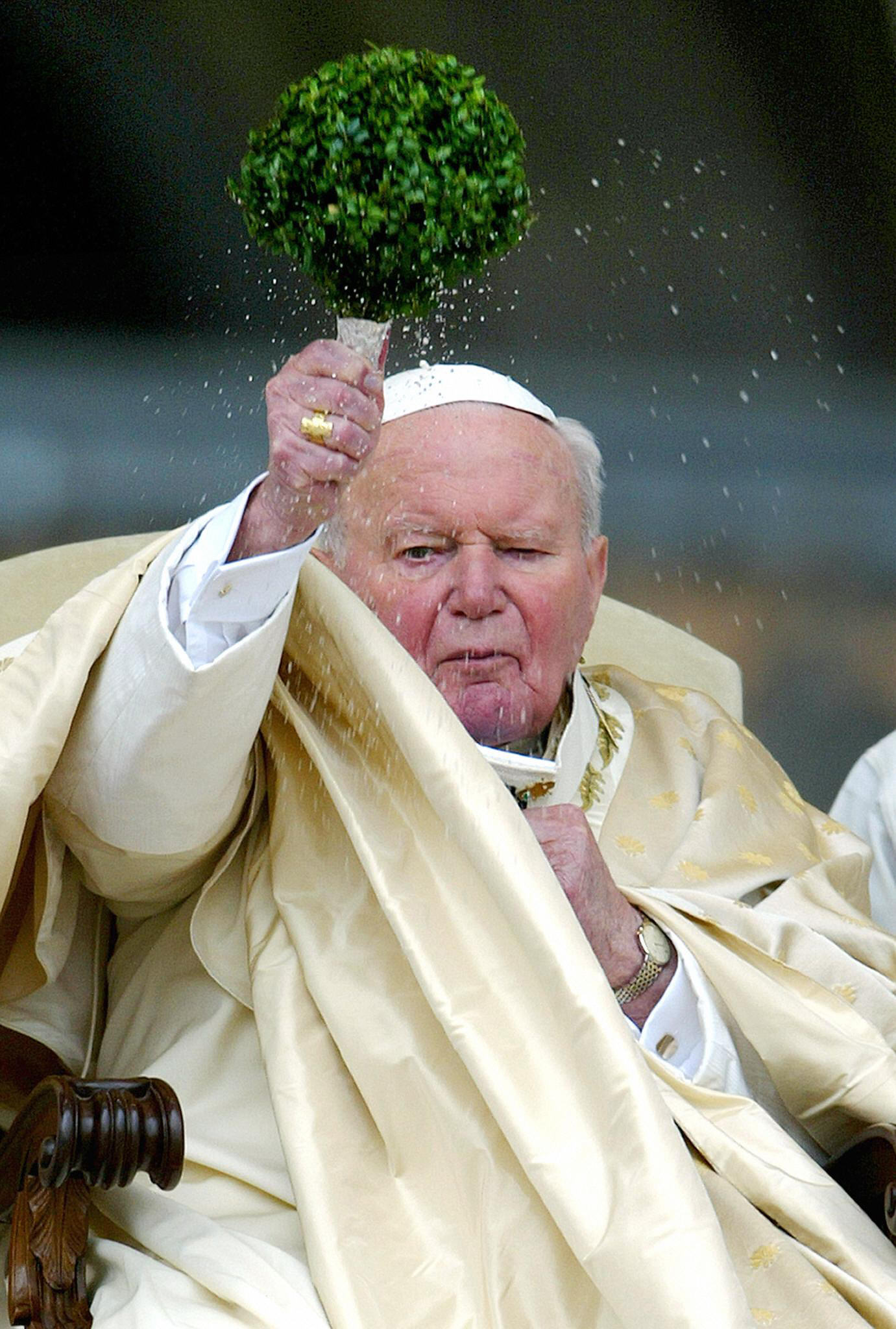 Le pape Jean-Paul II bénit les pèlerins rassemblés sur la place Saint-Pierre pour la messe de Pâques avec de l'eau bénite, le 11 avril 2003. | Source : Getty Images