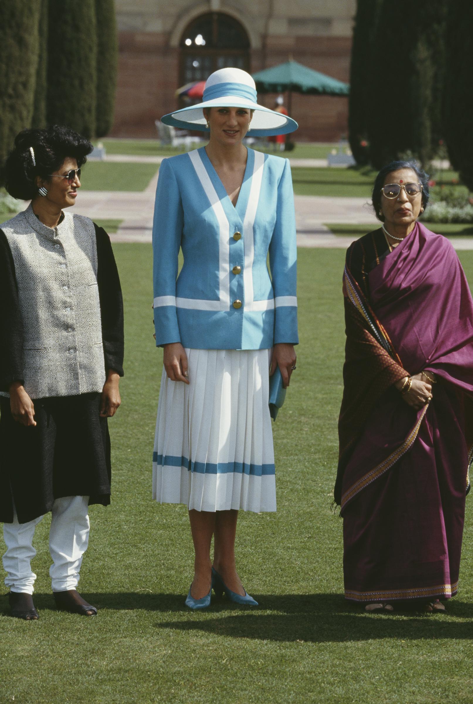 La princesse Diana se tient aux côtés de Janaki Venkataraman, l'épouse du président indien, au Rashtrapati Bhavan, le 12 février 1992. Dans son ensemble bleu et blanc, Diana respire l'élégance diplomatique, tandis que les femmes partagent un moment posé sur fond de grand palais présidentiel indien.