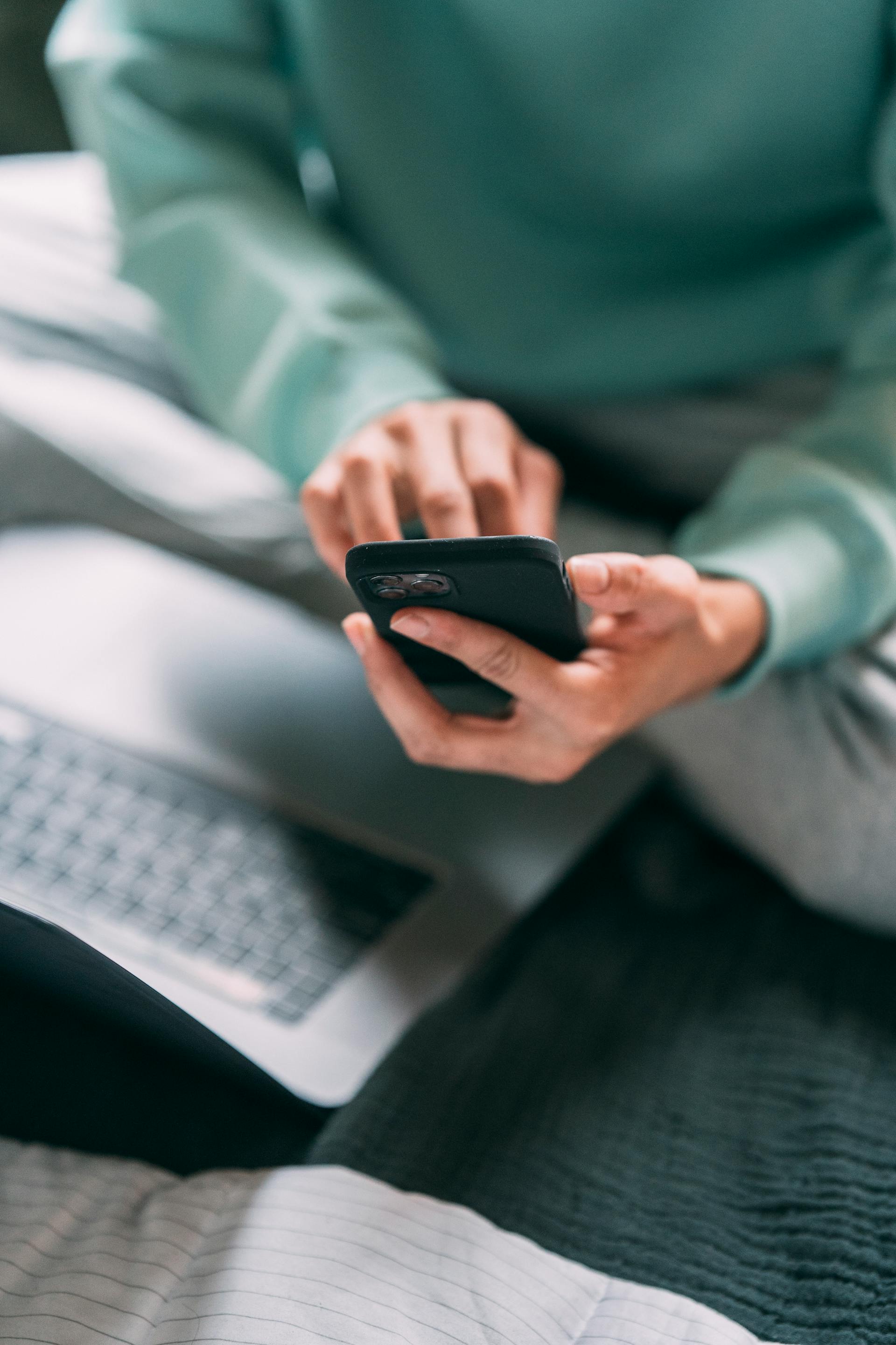Un homme méconnaissable vérifiant un smartphone | Source : Pexels