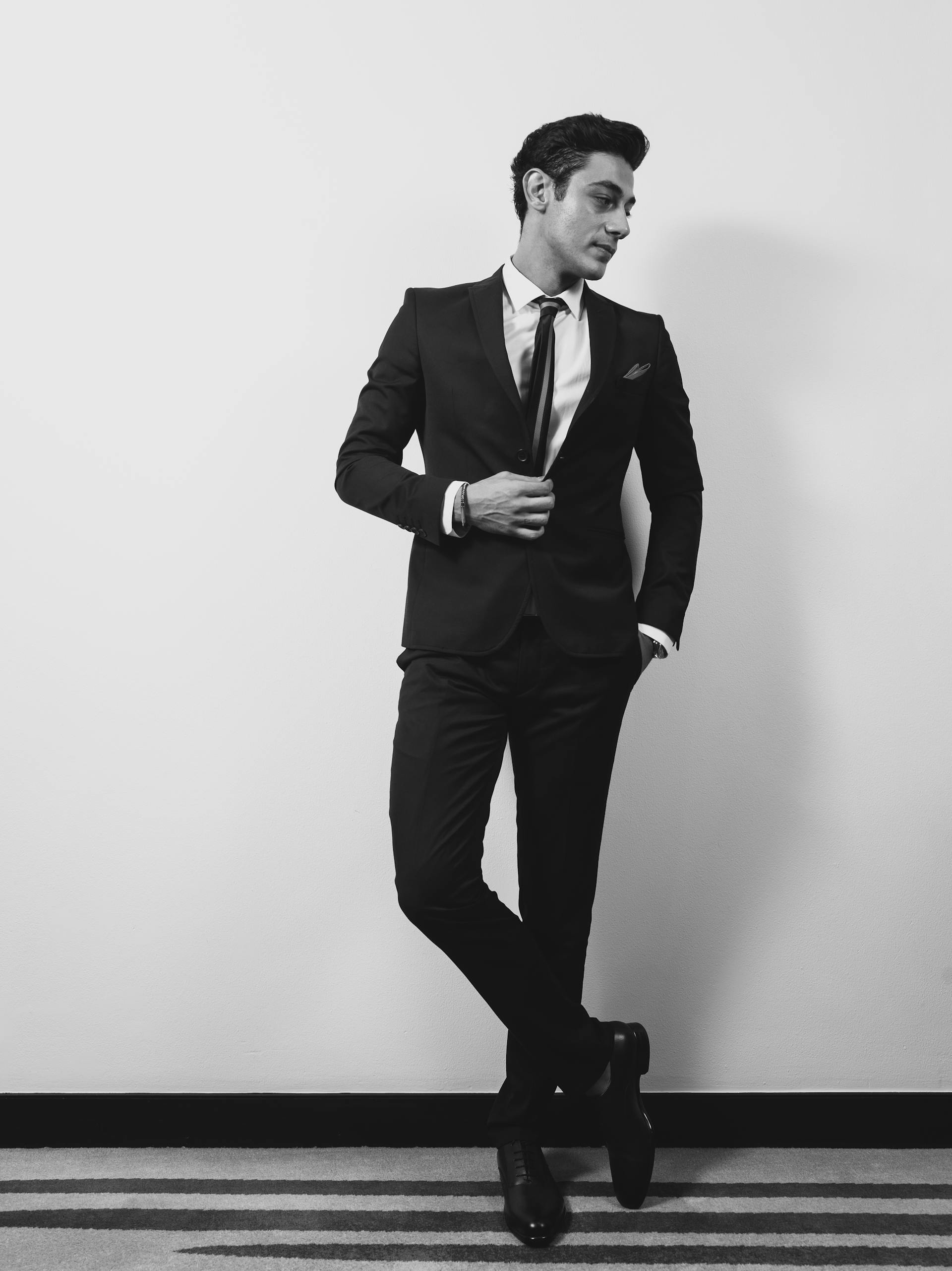 Un homme en costume debout contre un mur | Source : Pexels