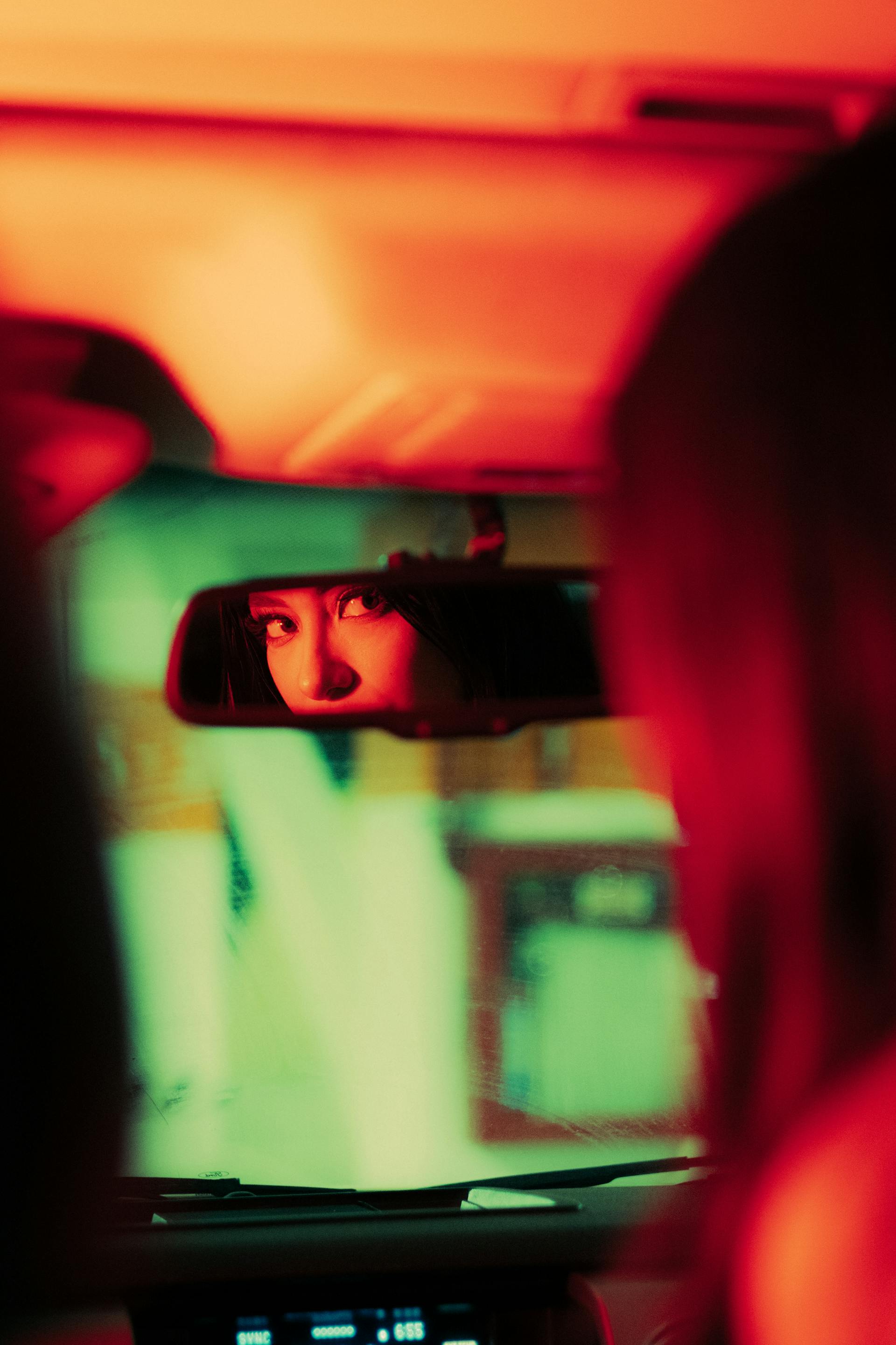 Une femme utilisant le rétroviseur d'une voiture | Source : Pexels