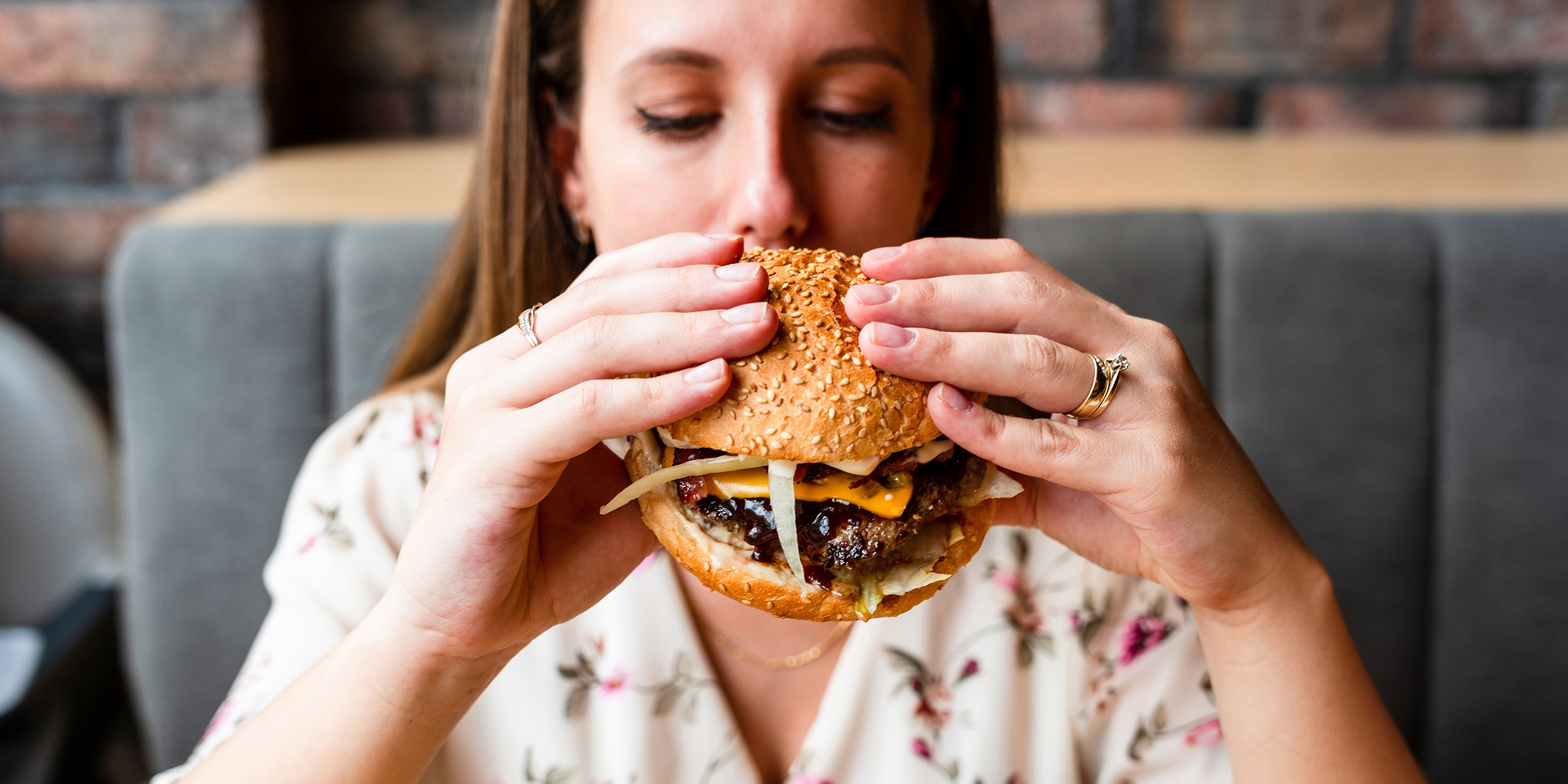 Une femme mangeant un hamburger | Source : Shutterstock