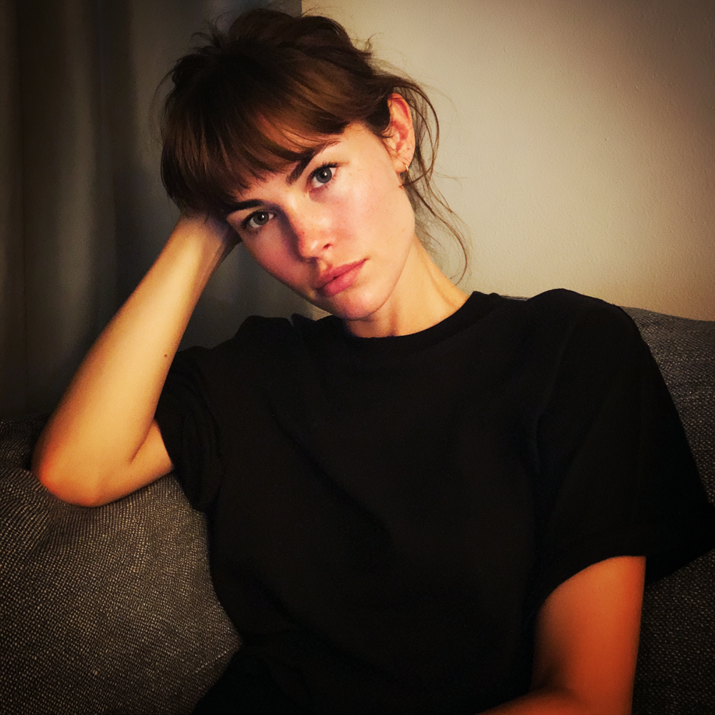 Une femme pensive assise sur un canapé | Source : Midjourney