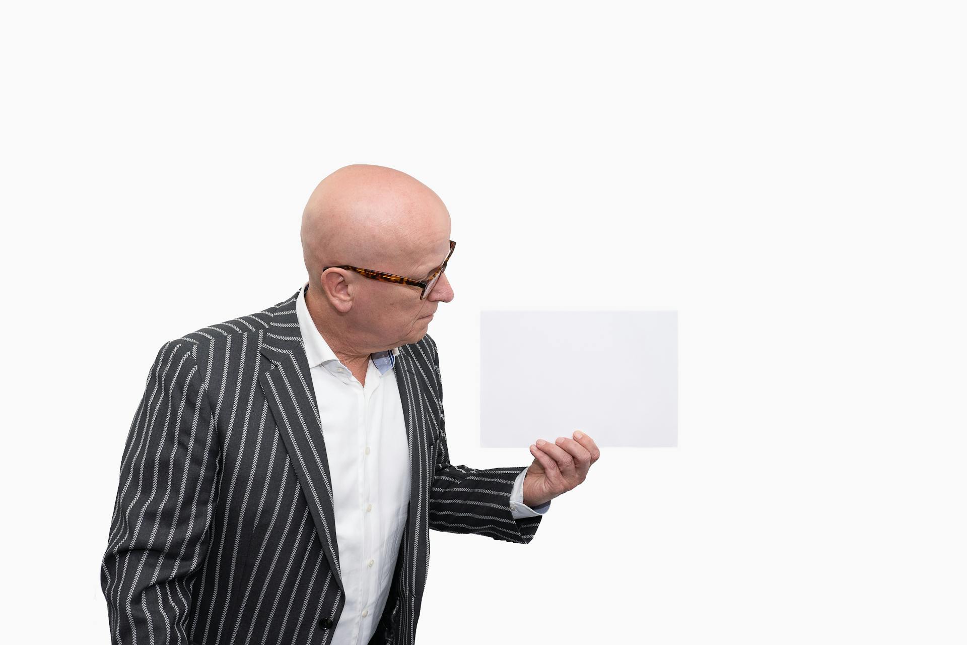 Un homme âgé tenant une feuille de papier | Source : Pexels