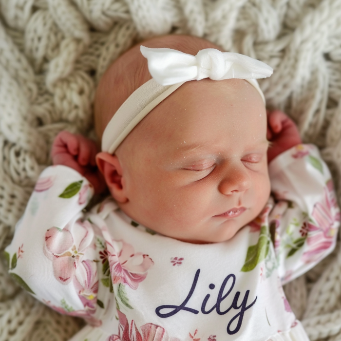 Une petite fille nouveau-née portant un t-shirt avec l'inscription « Lily » | Source : Midjourney