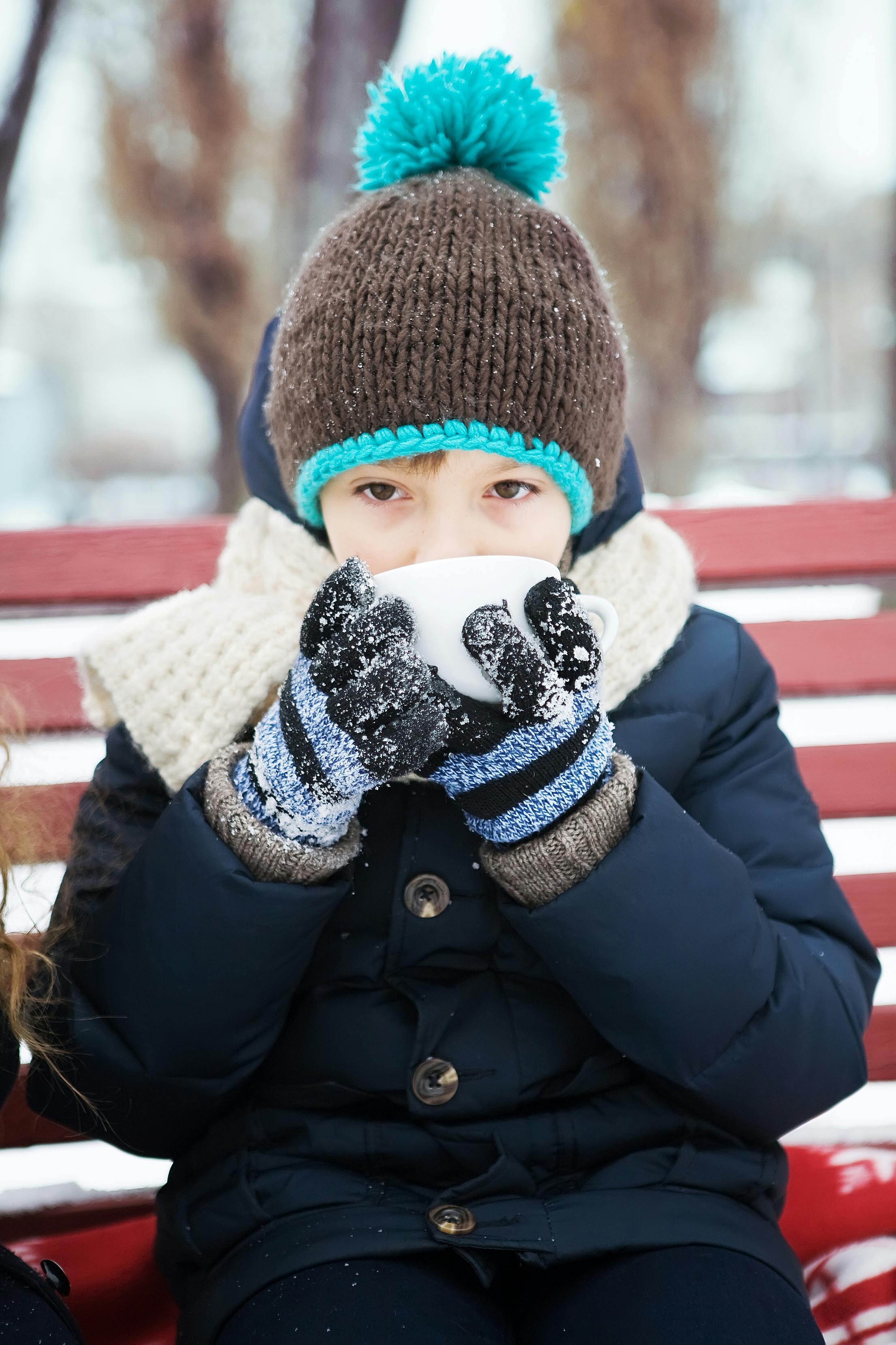 Un enfant qui boit quelque chose par temps de neige | Source : Pexels