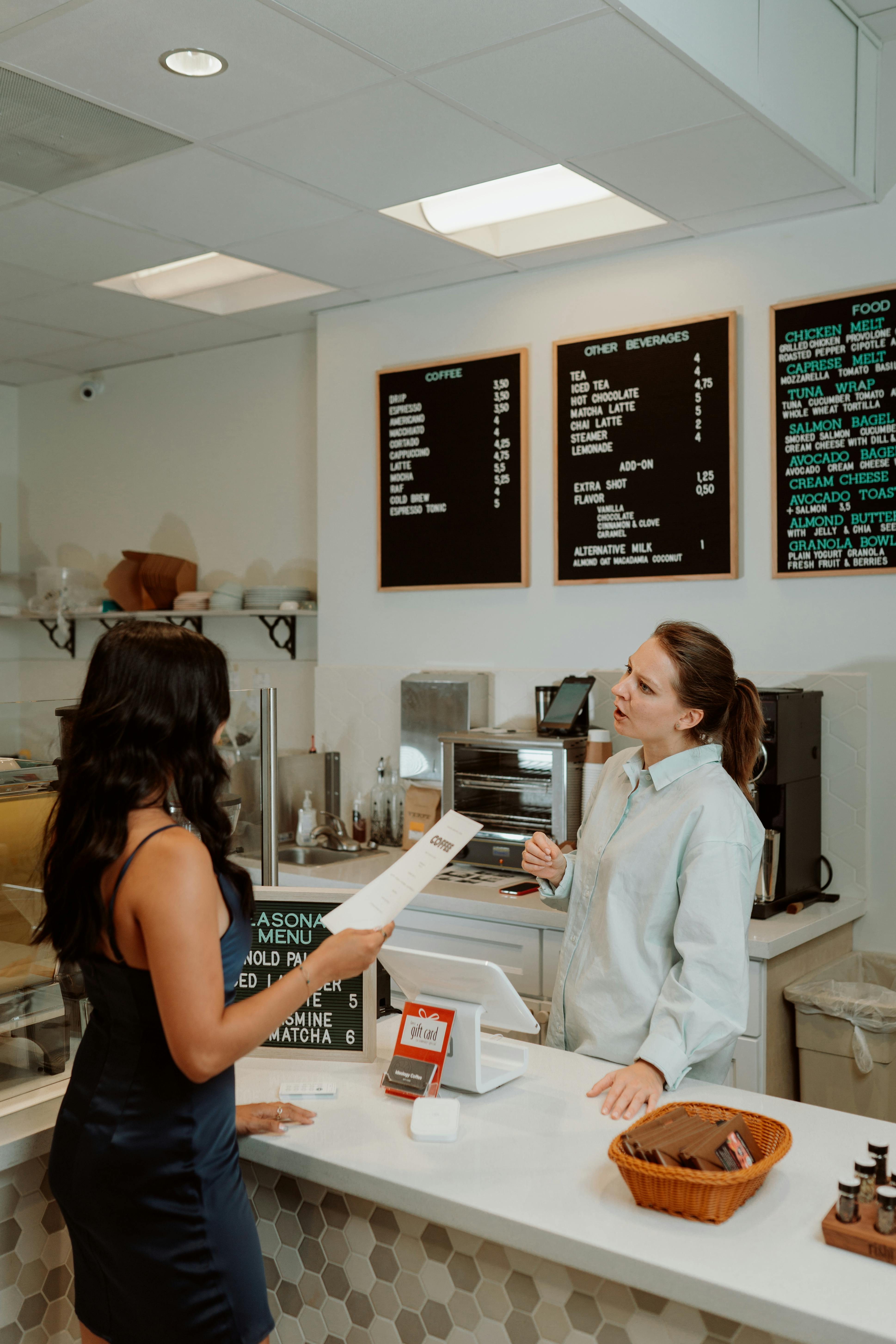 Une caissière en train de discuter avec une cliente | Source : Pexels