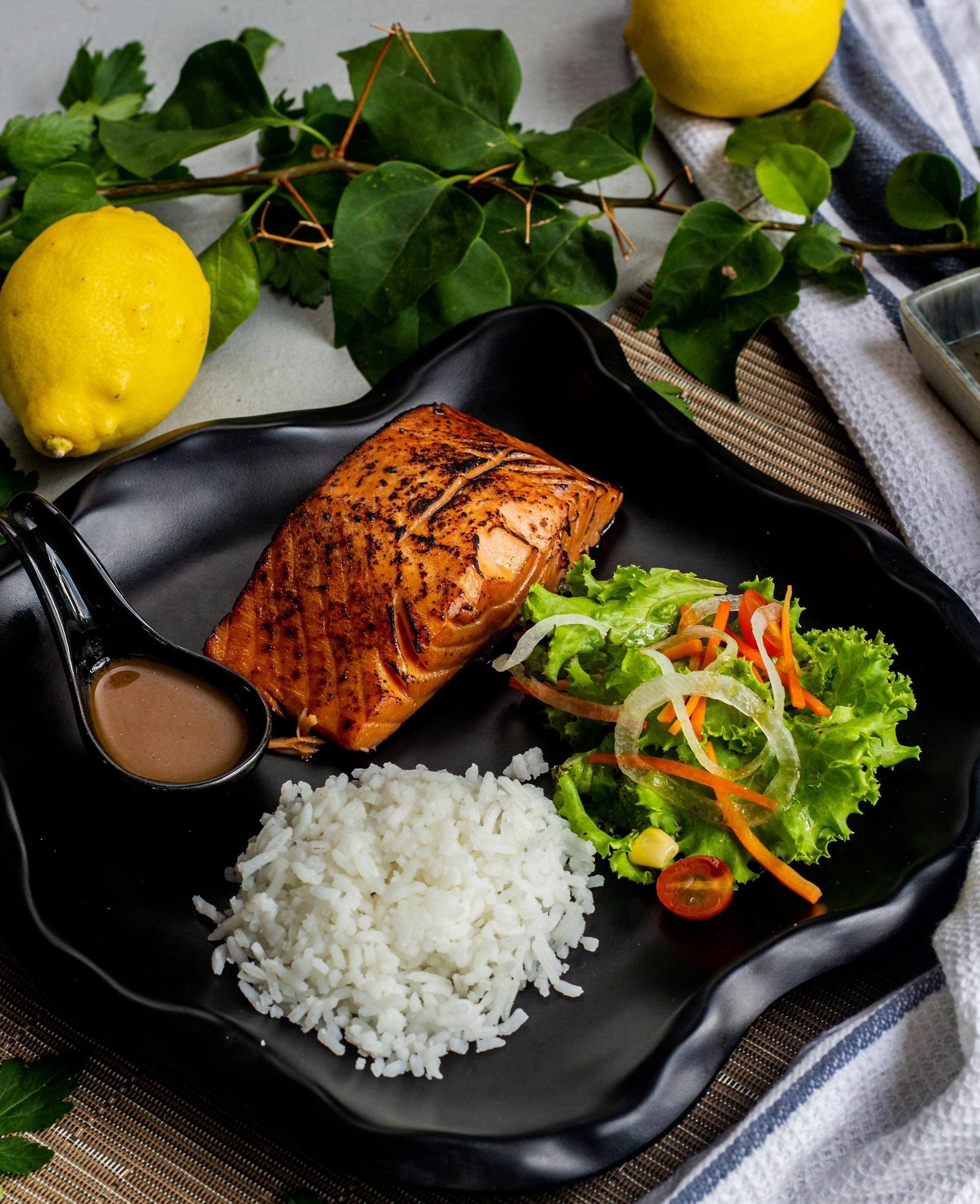 Poisson grillé et riz servi avec des légumes sur une assiette | Source : Pexels
