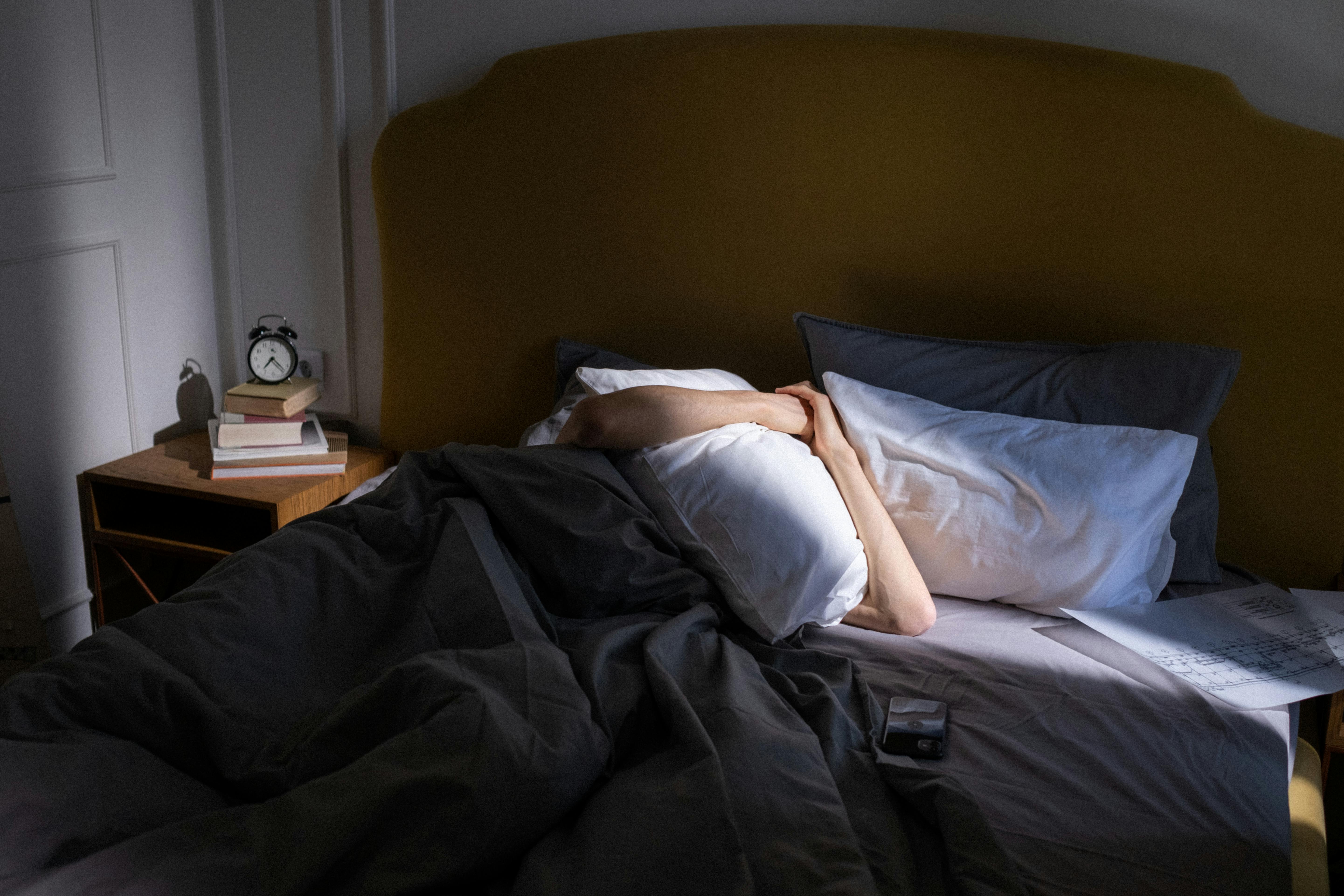Une personne se bloquant le visage avec un oreiller | Source : Pexels