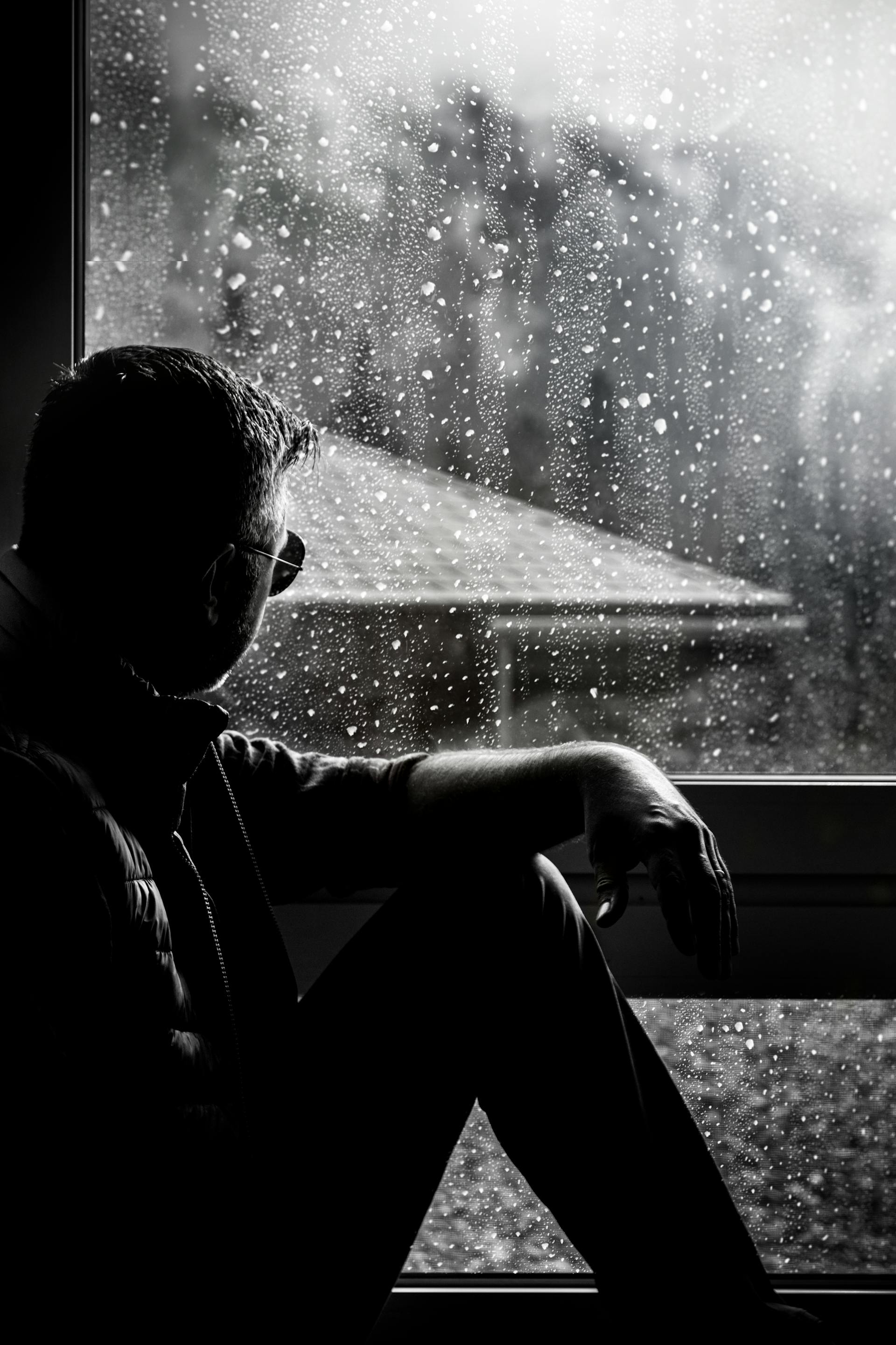 Un homme assis à côté d'une fenêtre | Source : Pexels