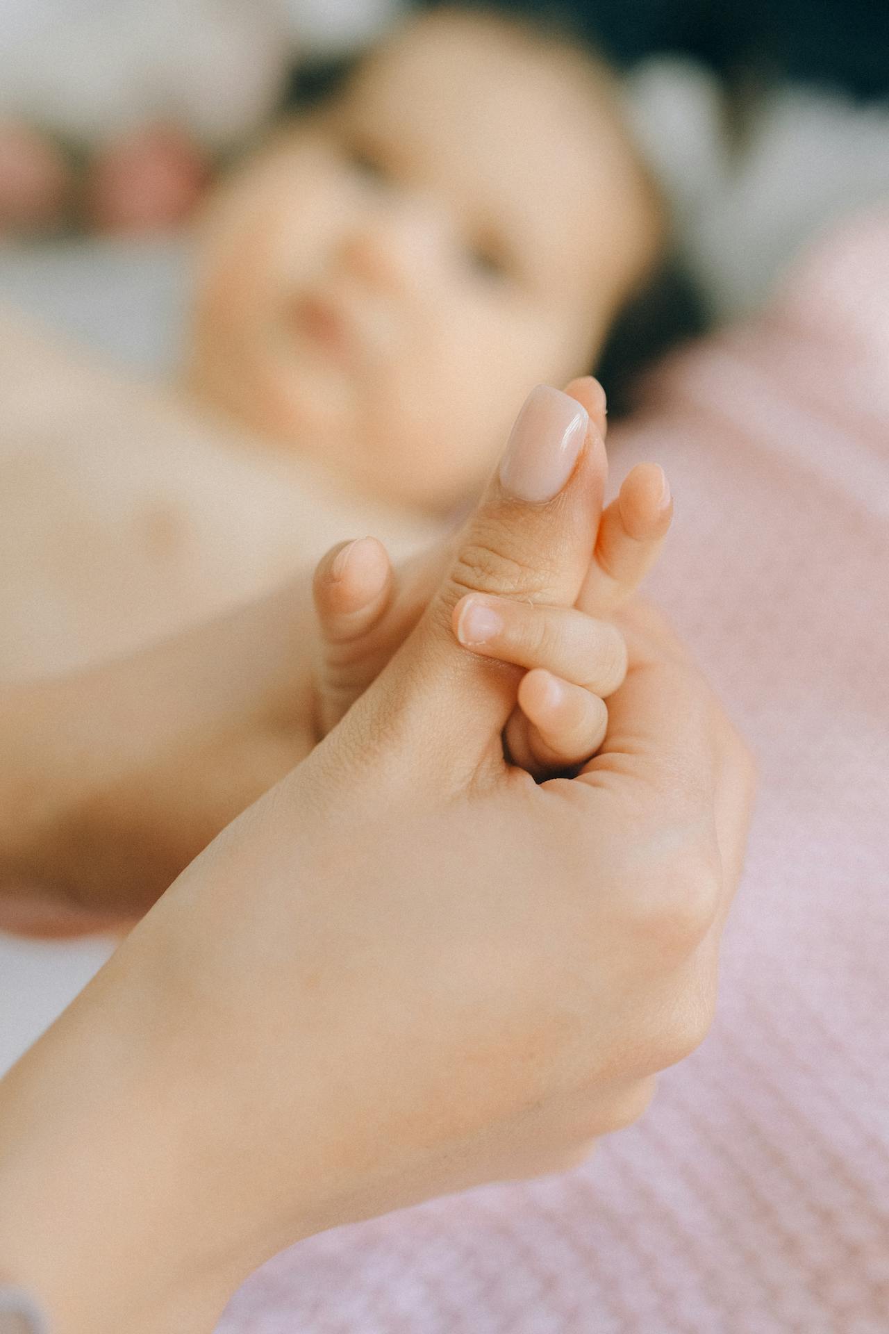 Une femme tenant la main d'un bébé | Source : Pexels