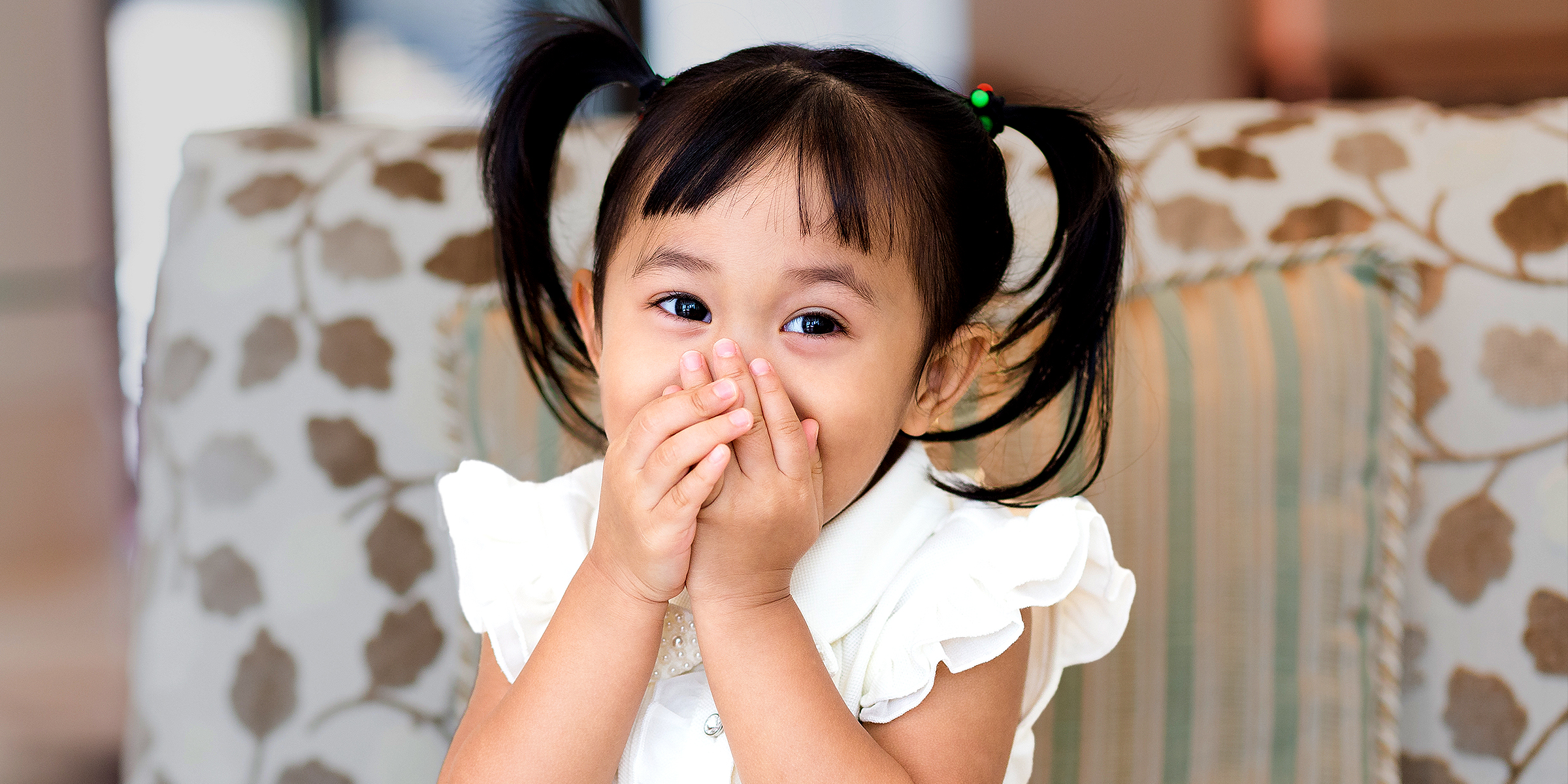 Une fille qui se couvre la bouche | Source : Shutterstock
