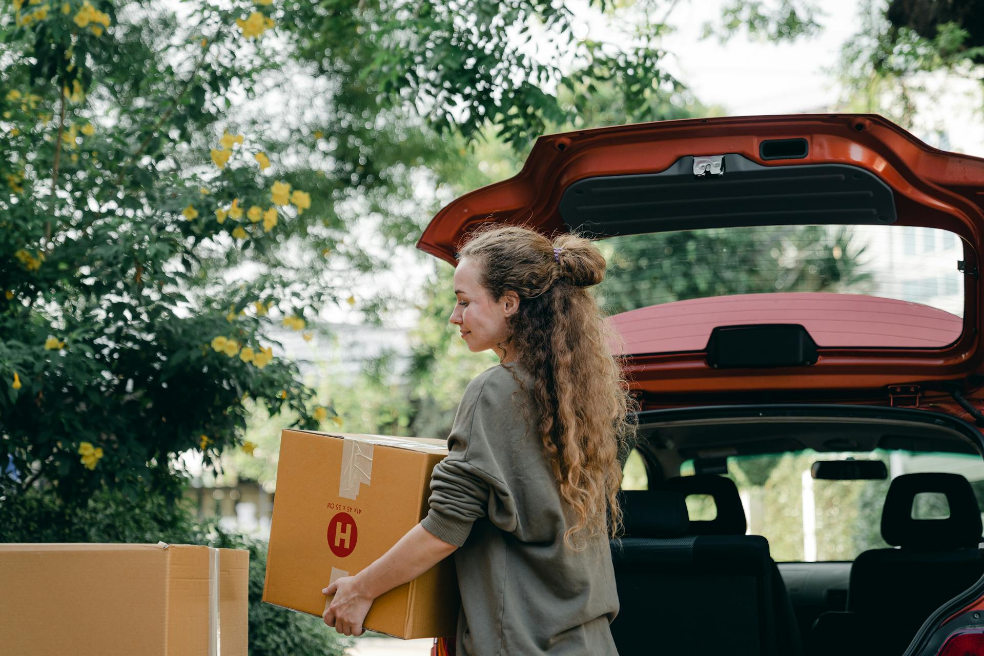 Une femme chargeant des cartons dans sa voiture | Source : Pexels
